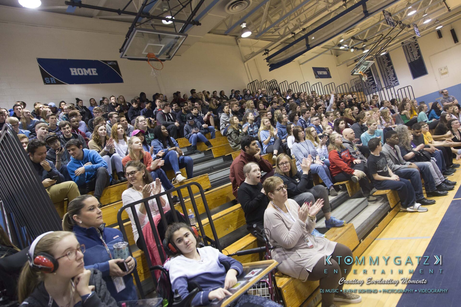 SR-Cultural-Day-2018-Low-Res-WM-19 - TOMMY GATZ ENTERTAINMENT A large group of people seated on bleachers in a gymnasium, watching an event. Some individuals are clapping.