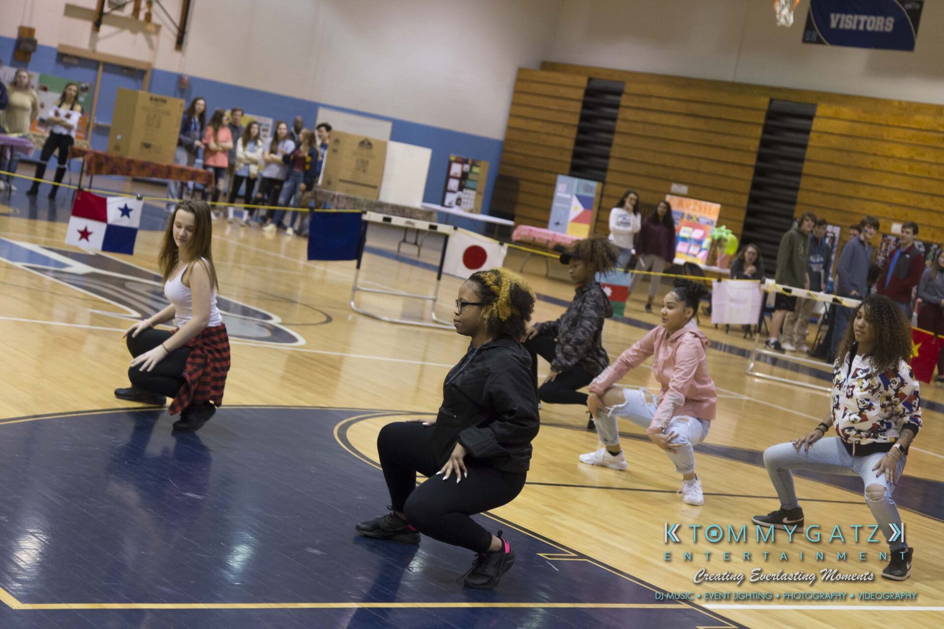 SR-Cultural-Day-2018-Low-Res-WM-22 - TOMMY GATZ ENTERTAINMENT A group of young people performing a dance routine on a gymnasium floor, with spectators watching in the background.