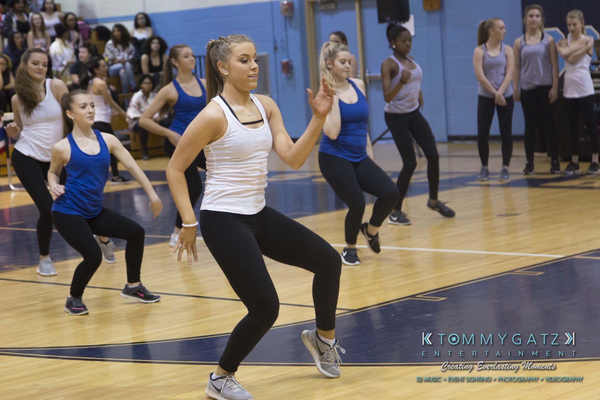 SR-Cultural-Day-2018-Low-Res-WM-3 - TOMMY GATZ ENTERTAINMENT A group of dancers in athletic wear perform on a gym floor, with some people watching in the background.