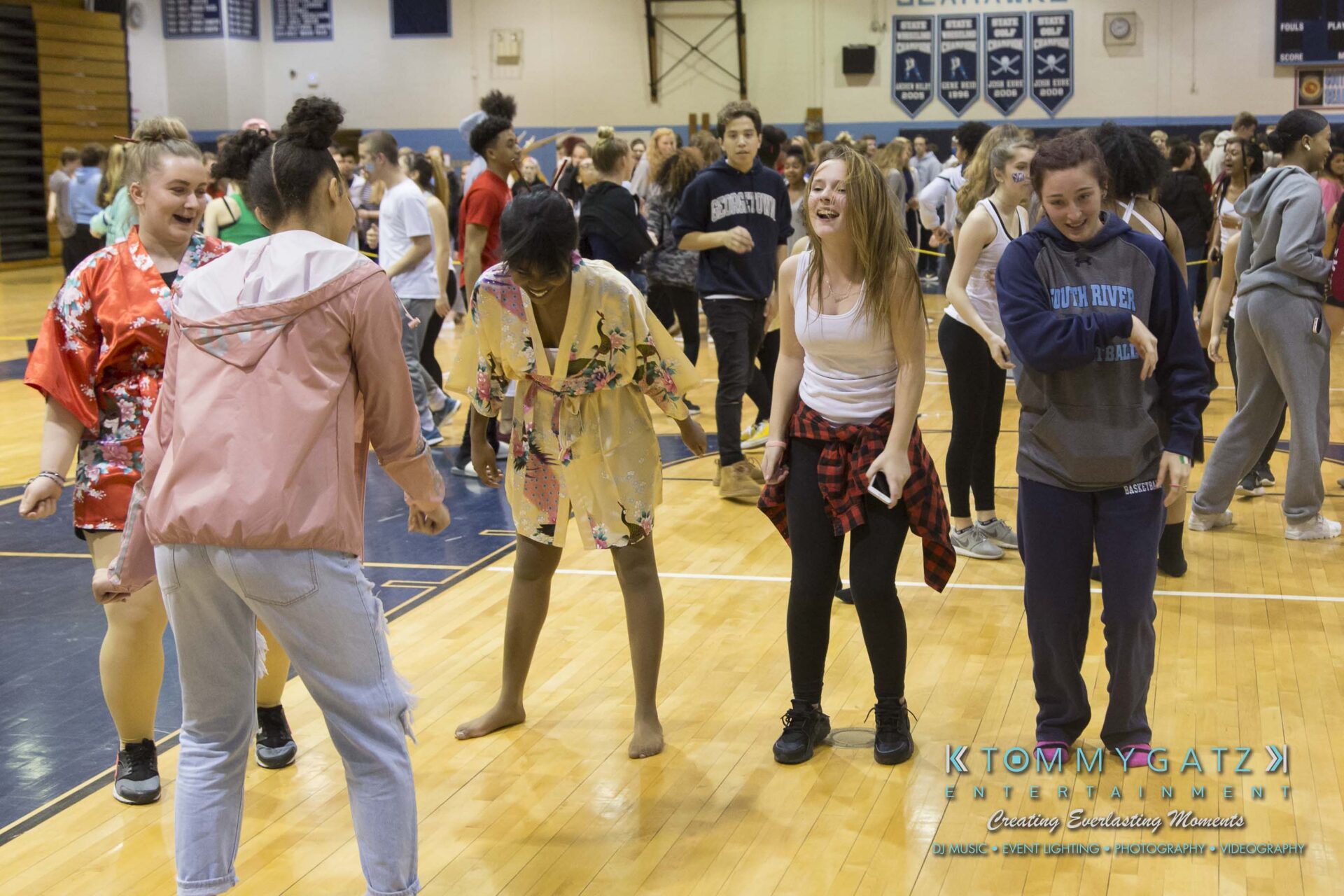 SR-Cultural-Day-2018-Low-Res-WM-51 - TOMMY GATZ ENTERTAINMENT A group of students laughing and dancing in a gymnasium during a casual event.