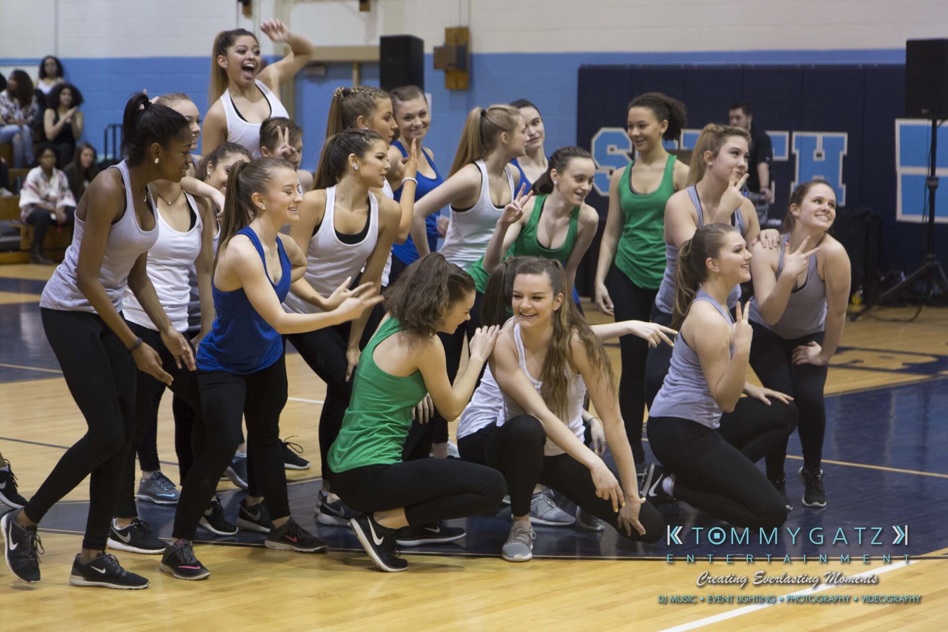 SR-Cultural-Day-2018-Low-Res-WM-6 - TOMMY GATZ ENTERTAINMENT A group of women in casual sportswear pose and laugh on a gymnasium floor.