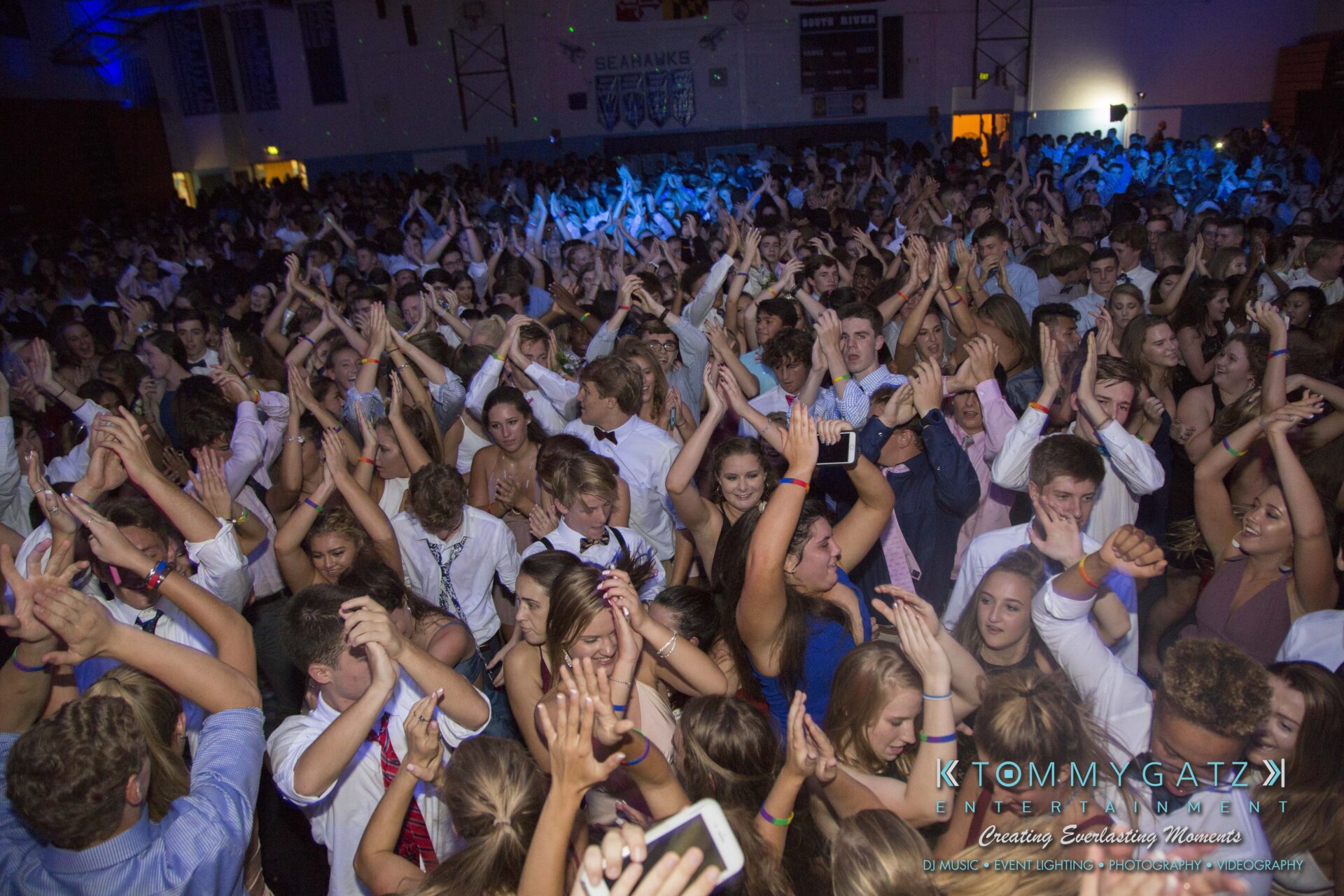 SR-HC-Dance-10717-BLOG-WM-60 - TOMMY GATZ ENTERTAINMENT Large crowd of people dancing energetically at a party or event, with arms raised and a lively atmosphere.