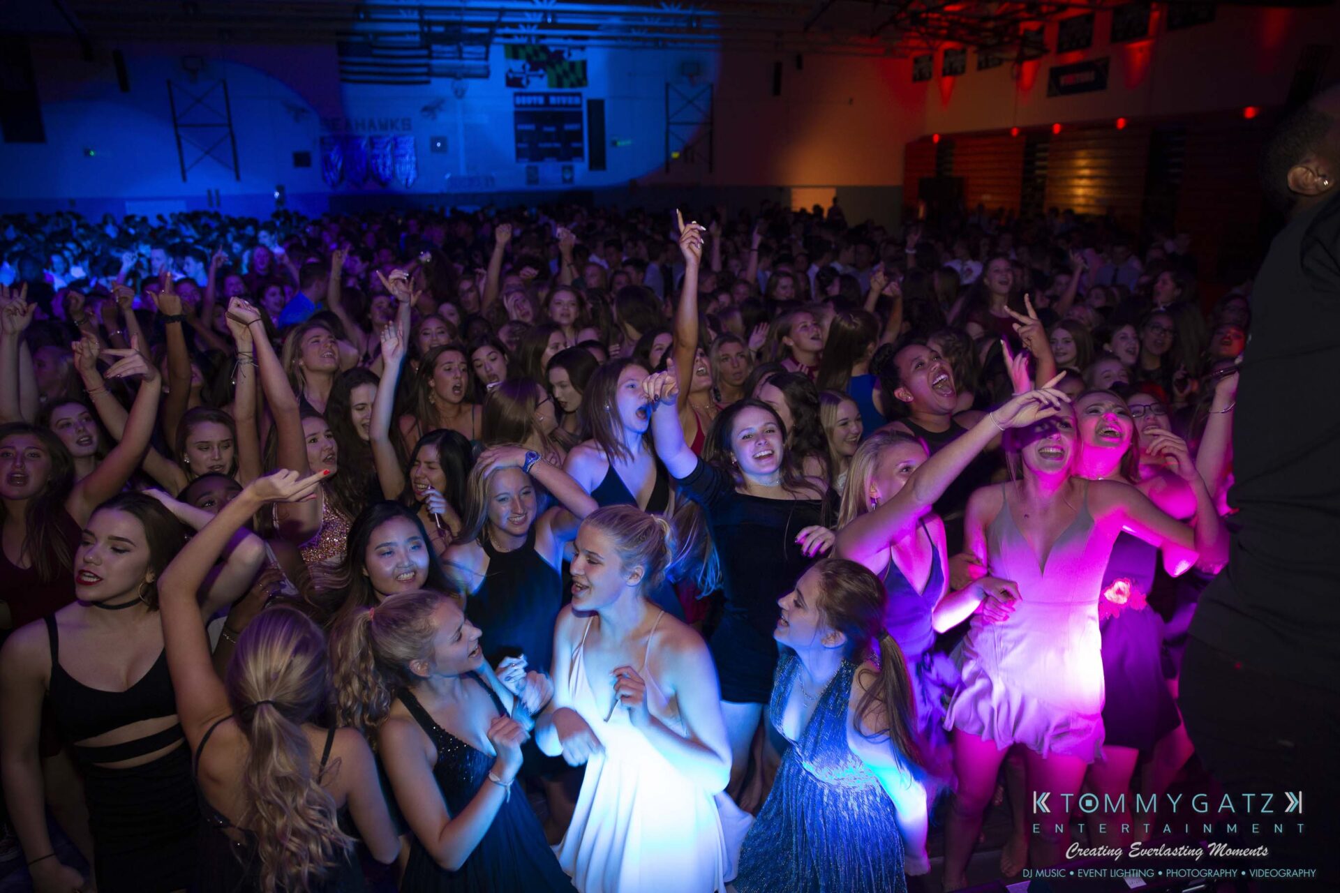 SR-Homecoming-102718-Carl-Low-Res-21 - TOMMY GATZ ENTERTAINMENT A crowded dance floor with people enjoying a lively event, colorful lighting illuminating the scene.