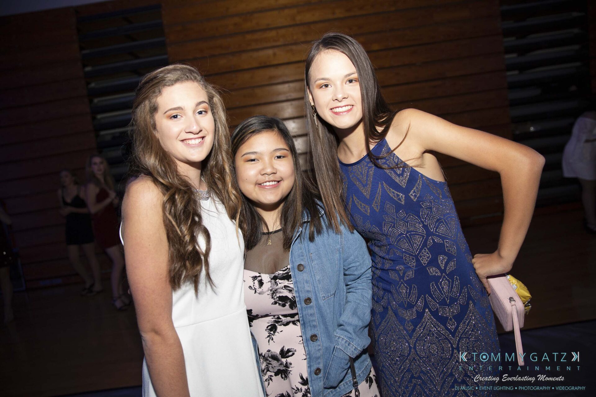 SR-Homecoming-102718-Carl-Low-Res-6 - TOMMY GATZ ENTERTAINMENT Three people smiling and posing together indoors, with a wooden wall in the background.