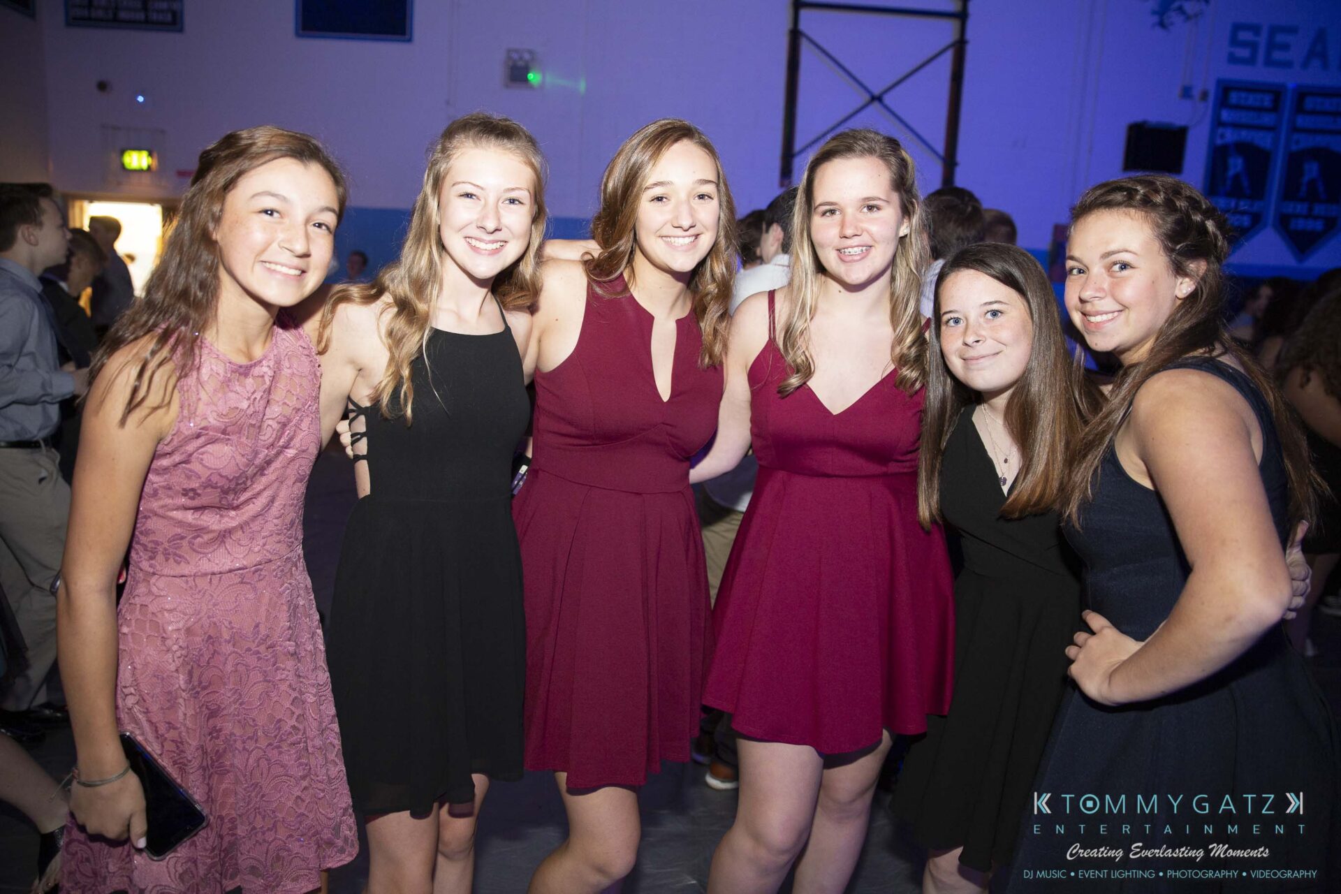 SR-Homecoming-102718-Carl-Low-Res-7 - TOMMY GATZ ENTERTAINMENT Five people in dresses pose together, smiling, at an indoor event.