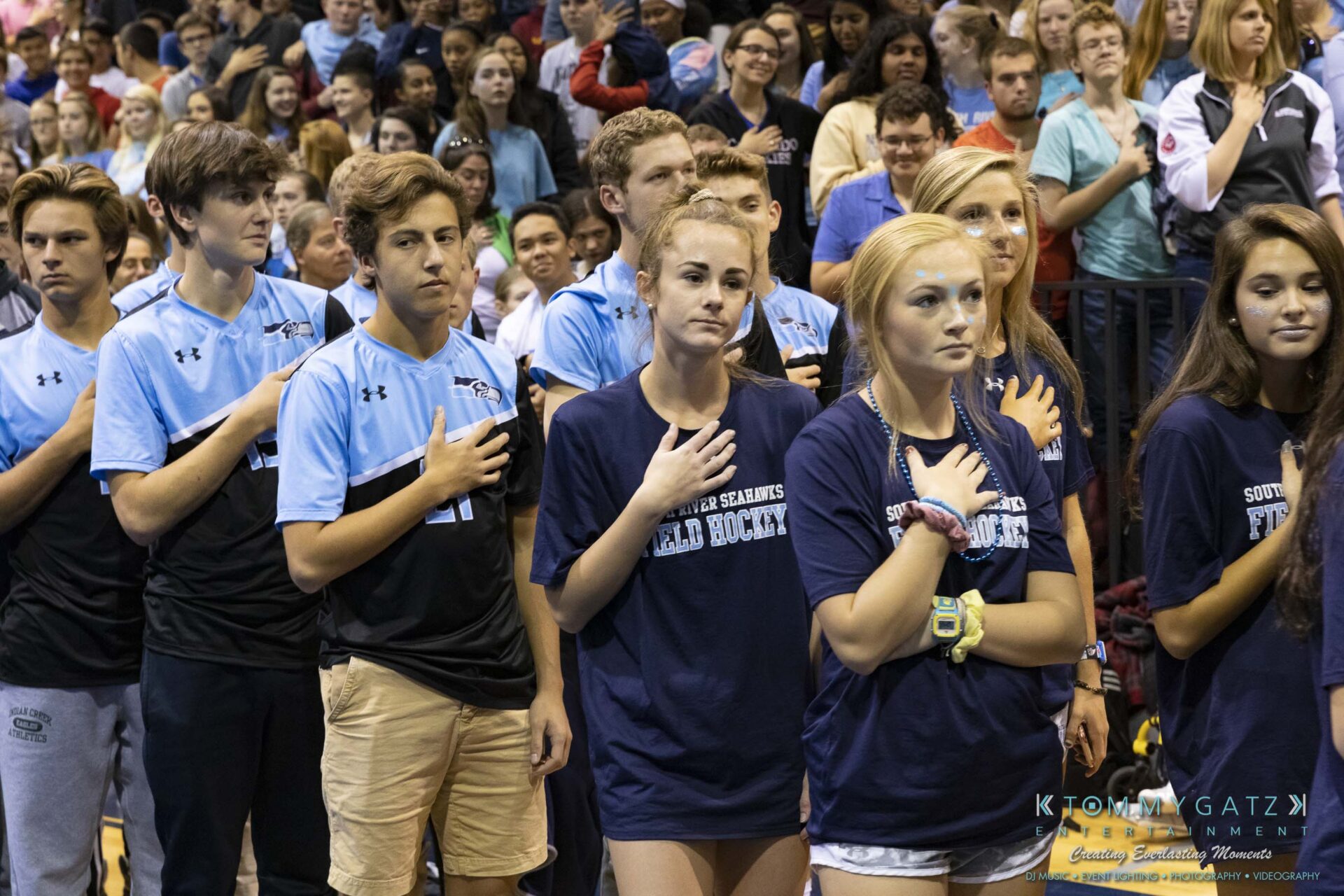 SR-Pep-Rally-102618-Carl-Low-Res-4 - TOMMY GATZ ENTERTAINMENT A group of students stands with their hands over their hearts during an event in a gymnasium.