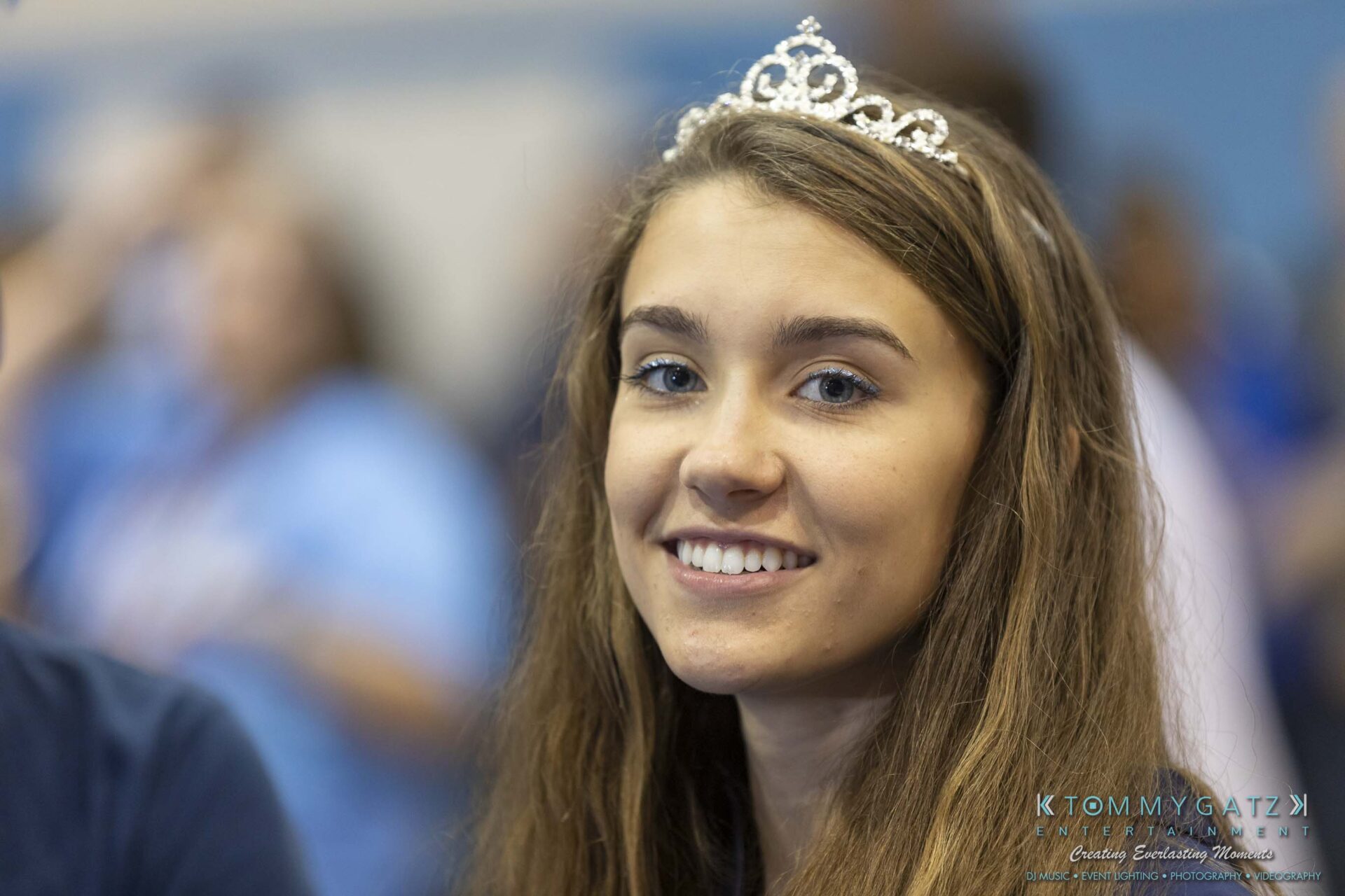 SR-Pep-Rally-102618-Carl-Low-Res-54 - TOMMY GATZ ENTERTAINMENT Young woman wearing a tiara, smiling in a crowded indoor setting.