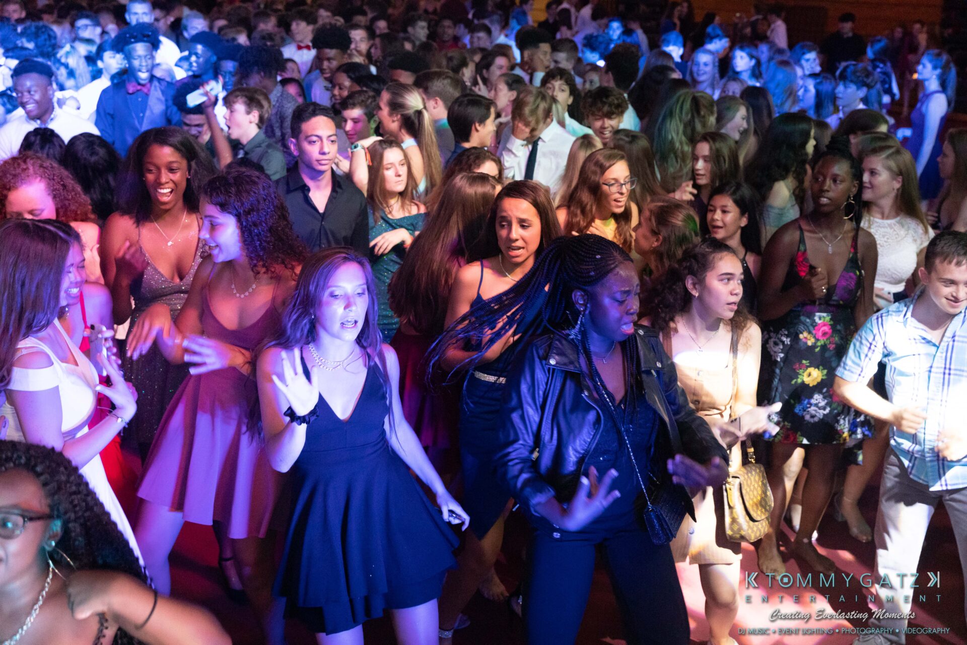 092819-Broadneck-Homecoming-Low-Res-WM-58 - TOMMY GATZ ENTERTAINMENT A large group of young people dancing in a crowded indoor venue with colorful lighting.