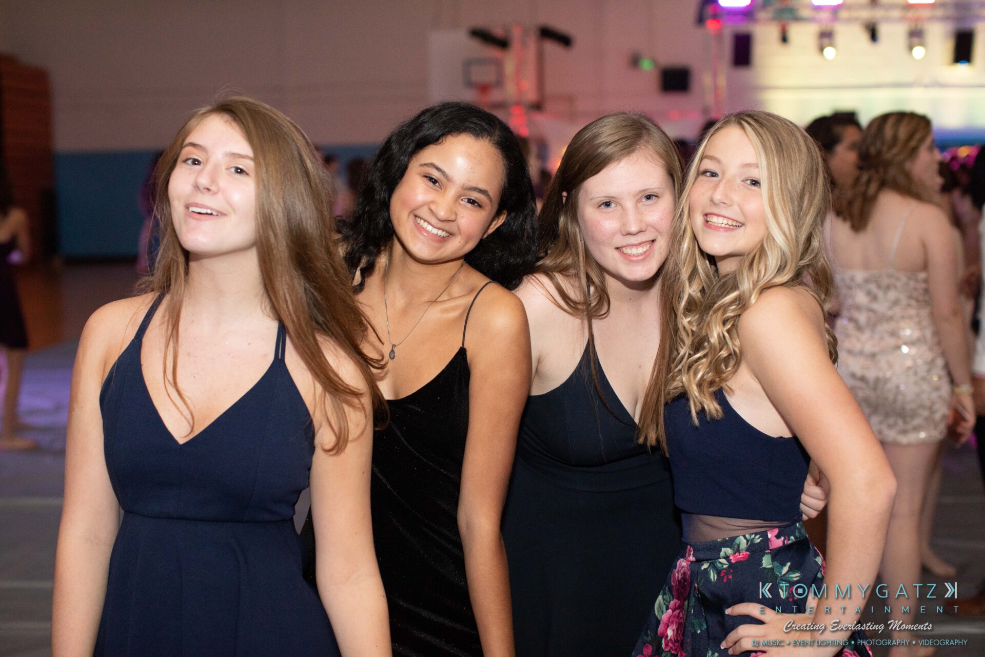100519-South-River-HC-Dance-Low-Res-WM-13 - TOMMY GATZ ENTERTAINMENT Four young women pose together at a formal event, all smiling.