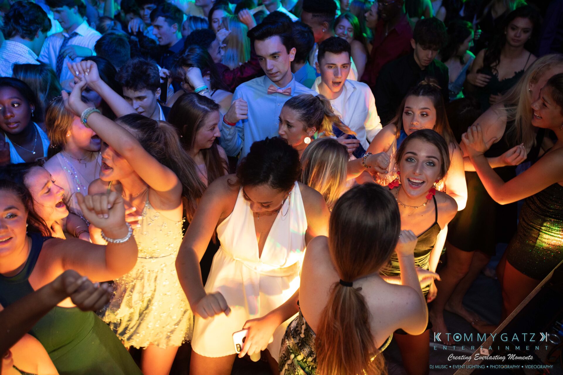 100519-South-River-HC-Dance-Low-Res-WM-72 - TOMMY GATZ ENTERTAINMENT A crowded dance floor with young people dancing energetically under colorful lights.