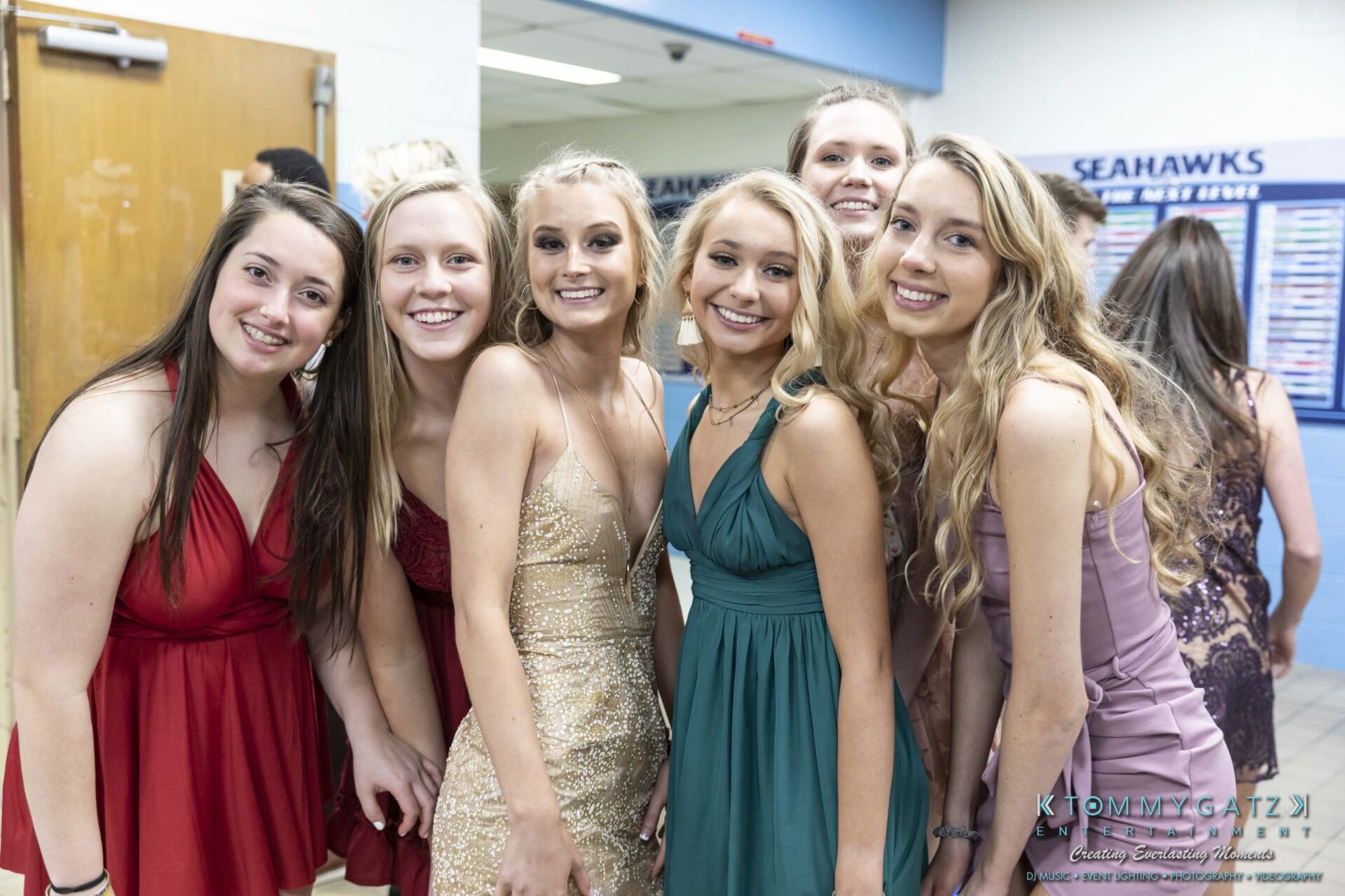 SR-Spring-Fling-032319-FINALS-Low-Res-WM-19 - TOMMY GATZ ENTERTAINMENT Group of six young women in formal dresses posing and smiling in a school hallway.