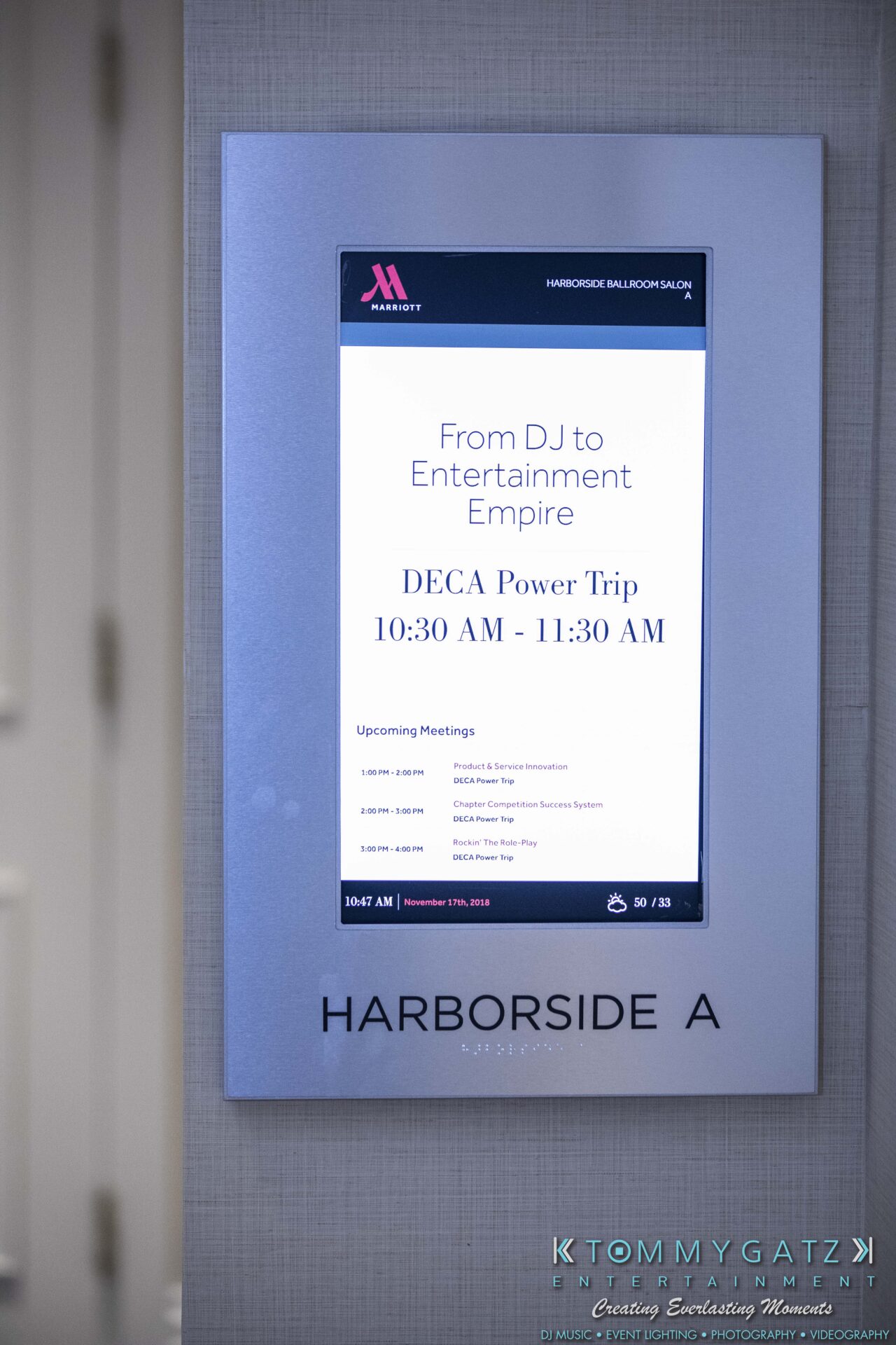 DECA-2018-Low-Res-WM-16 - TOMMY GATZ ENTERTAINMENT Signage at Harborside A displaying a DECA Power Trip schedule from 10:30 AM to 11:30 AM.