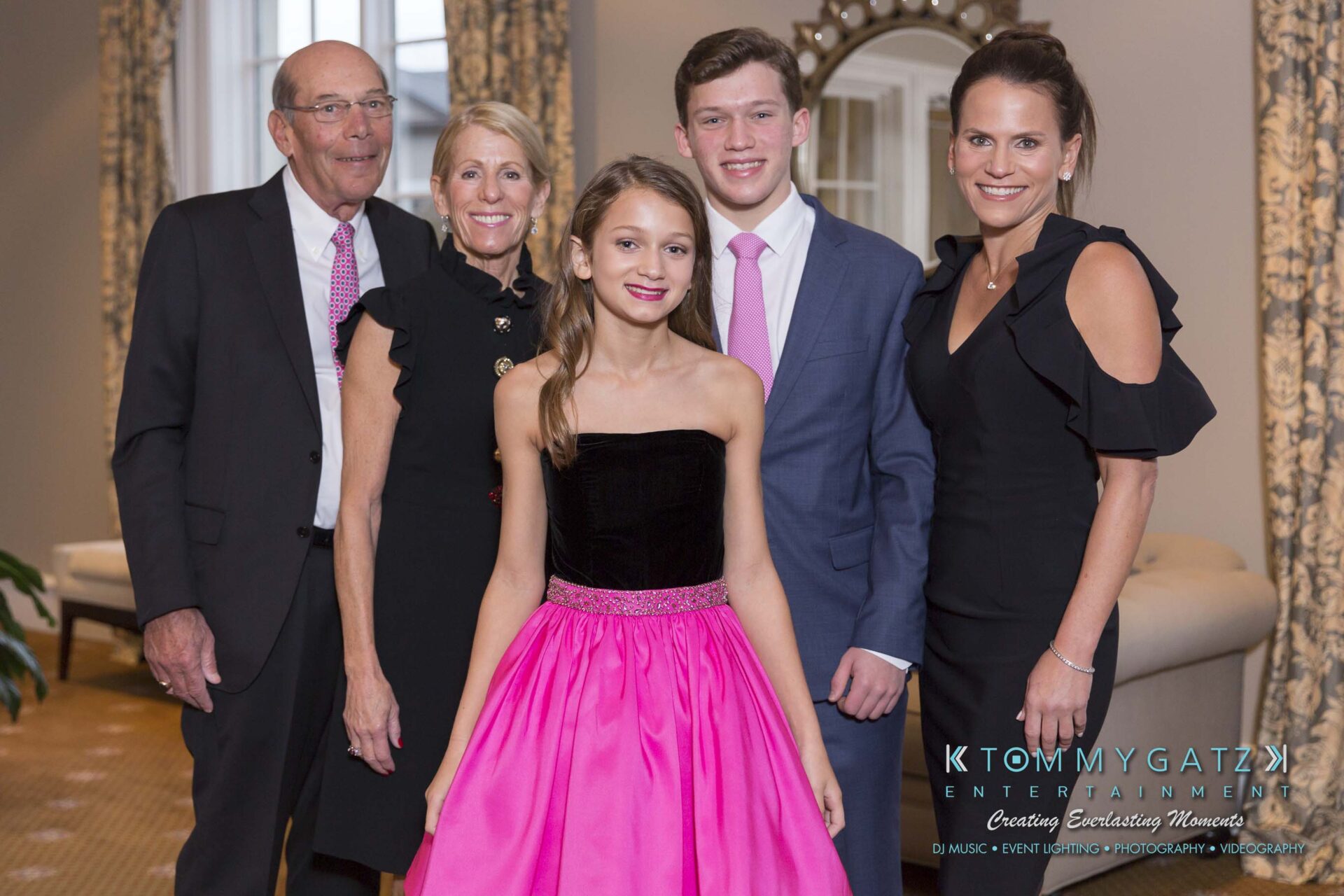 Dylans-Bat-Mitzvah-PORTRAITS-Low-Res-WM-33 - TOMMY GATZ ENTERTAINMENT A group of people dressed formally, posing together in a well-lit room.