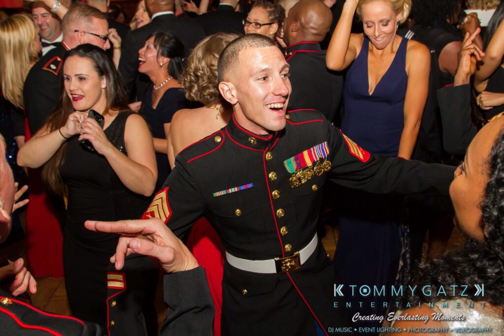 Marine-Lo-Res-145 - TOMMY GATZ ENTERTAINMENT A group of people in formal military uniforms and evening attire are dancing and socializing at an event.