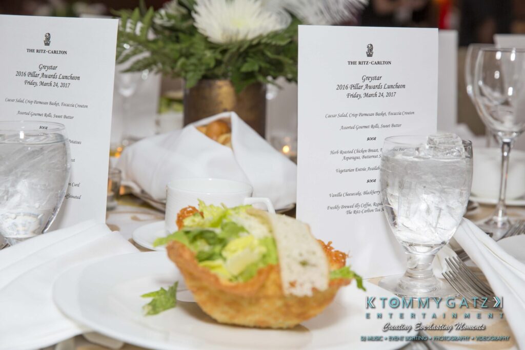 Pillar-Awards-Final-3-24-17-Blog-WM-19 - TOMMY GATZ ENTERTAINMENT A table setting featuring a plated salad, two glasses of water, and event menus for the 2016 awards luncheon at The Ritz-Carlton.