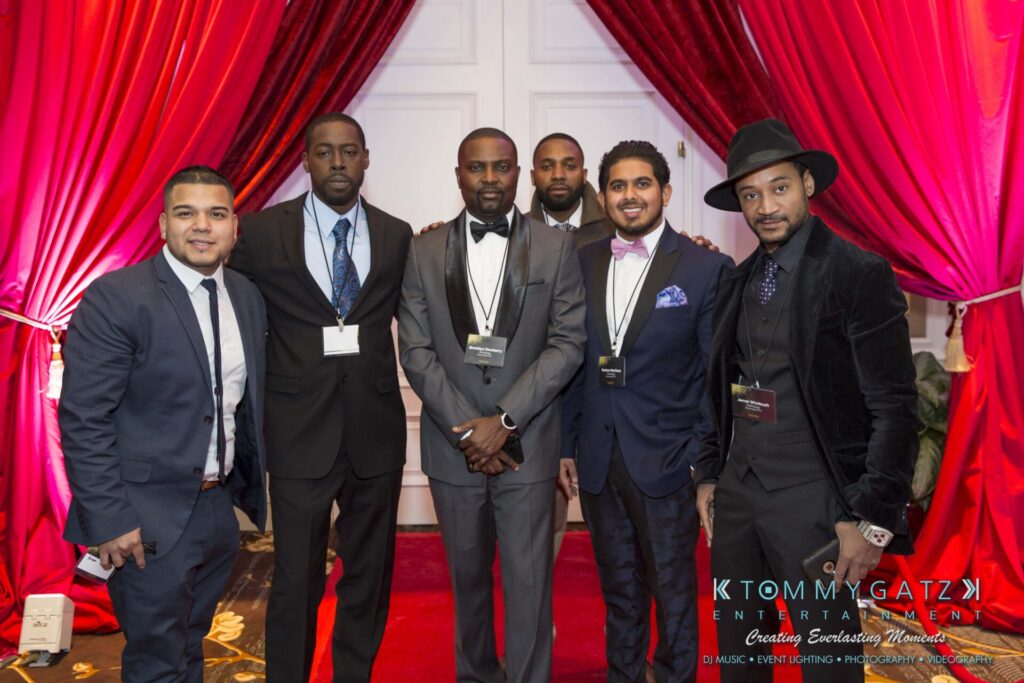 Pillar-Awards-Final-3-24-17-Blog-WM-46 - TOMMY GATZ ENTERTAINMENT A group of six men dressed formally pose together on a red-carpeted area with curtains in the background.