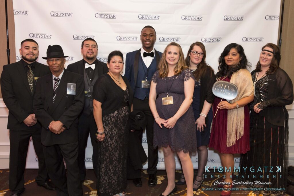 Pillar-Awards-Final-3-24-17-Blog-WM-73 - TOMMY GATZ ENTERTAINMENT A group of nine people dressed formally, standing together and posing in front of a step-and-repeat banner with "Greystar" logos.