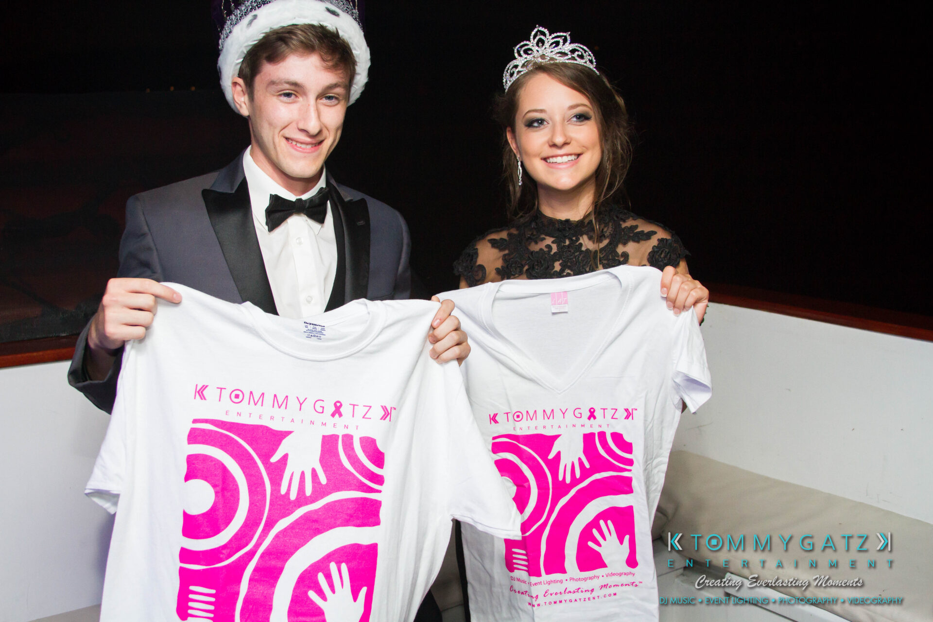 untitled-11 - TOMMY GATZ ENTERTAINMENT A young man and woman in formal attire and crowns hold up Tommy Gatz Entertainment t-shirts and smile at the camera.