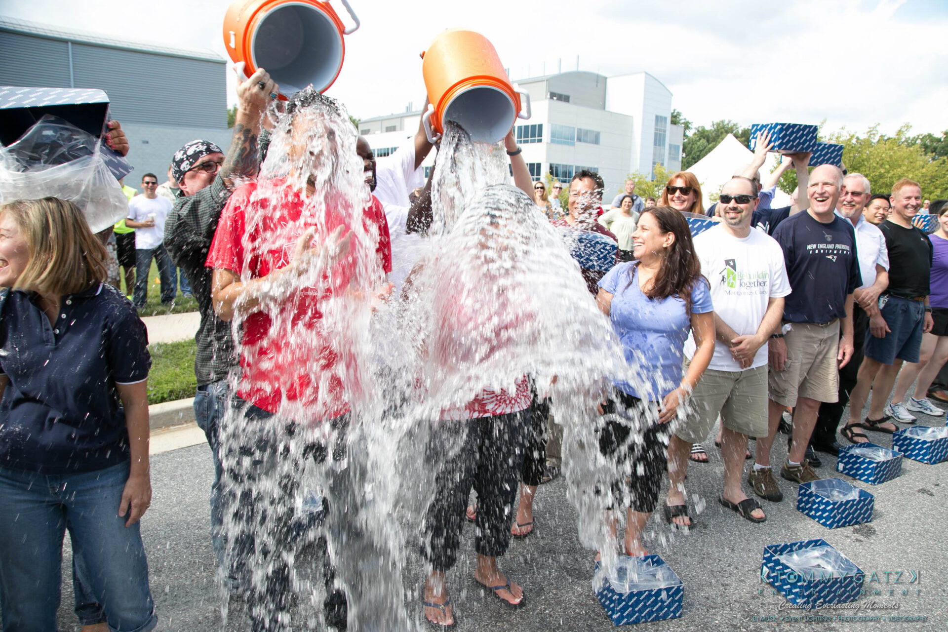 untitled-41 - TOMMY GATZ ENTERTAINMENT Group of people participating in the Ice Bucket Challenge, with two individuals pouring ice water over themselves while others watch and prepare with ice buckets.