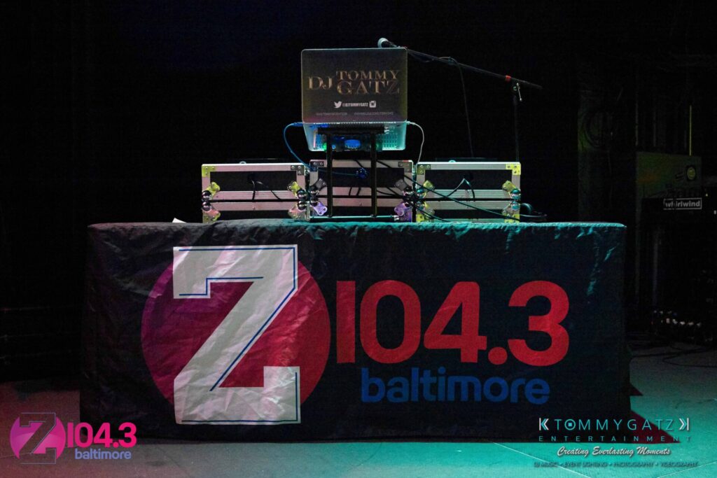 Intern-John-Peer-Pressure-Comedy-Show-Baltimore-7-14-17-Blog-Watermark-1 - TOMMY GATZ ENTERTAINMENT DJ setup on stage with a black tablecloth displaying "Z 104.3 Baltimore" and "KTOMMY GATZ ENTERTAINMENT" logos.