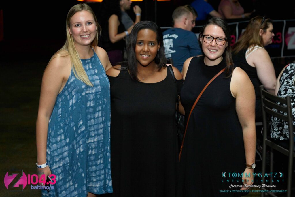 Intern-John-Peer-Pressure-Comedy-Show-Baltimore-7-14-17-Blog-Watermark-12 - TOMMY GATZ ENTERTAINMENT Three people smiling and standing together indoors, with a logo in the bottom left corner and text on the bottom right.
