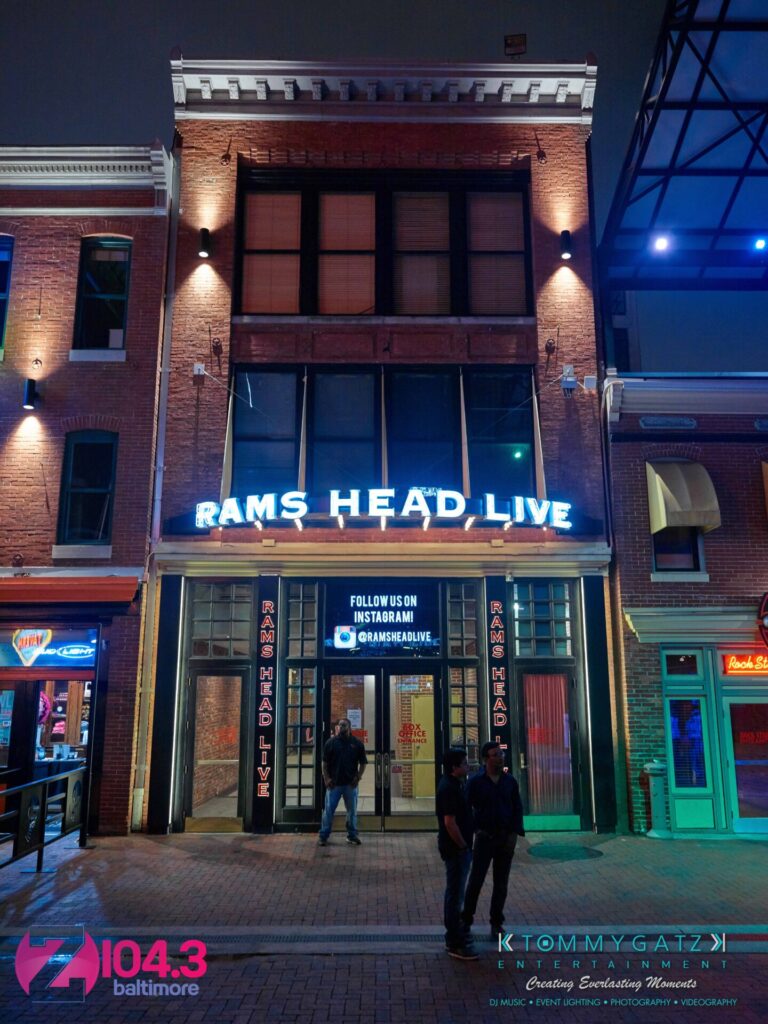Intern-John-Peer-Pressure-Comedy-Show-Baltimore-7-14-17-Blog-Watermark-3 - TOMMY GATZ ENTERTAINMENT Exterior of Rams Head Live venue at night, with neon signage and a digital display above the entrance. Two people stand outside near the entrance.