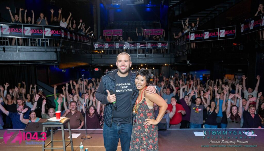 Intern-John-Peer-Pressure-Comedy-Show-Baltimore-7-14-17-Blog-Watermark-40 - TOMMY GATZ ENTERTAINMENT Two people pose on stage with a cheering crowd in the background. A banner displays "Z104.3 Baltimore.