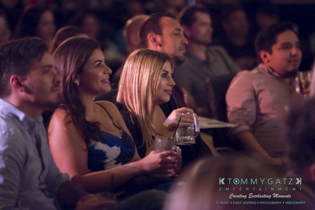 Intern-John-Pressure-Comedy-Tour-ARLINGTON-BLOG-WM-149-of-323 - TOMMY GATZ ENTERTAINMENT Audience members seated, holding drinks, and watching an event with interest.