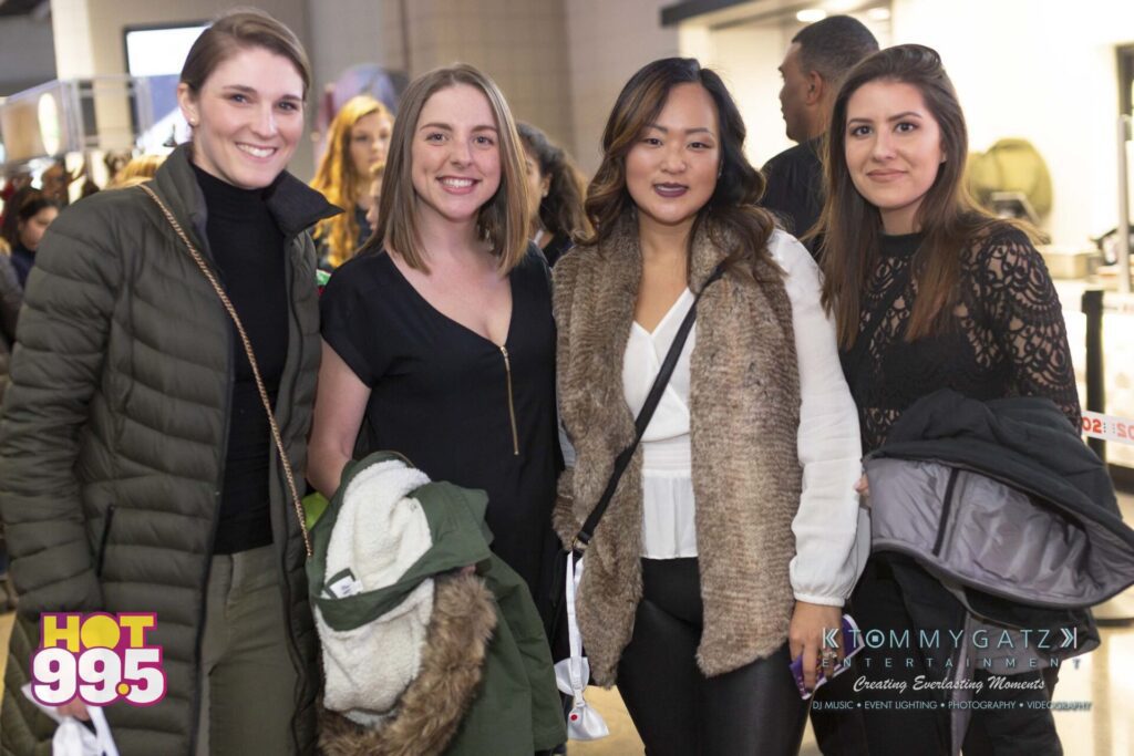 Jingle-Ball-2018-BTS-15 - TOMMY GATZ ENTERTAINMENT Four people posing indoors, wearing casual and semi-formal clothing.