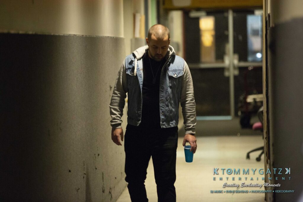 LWYD-Comedy-Tour-Baltimore-060118-FINALS-Low-Res-Watermark-193 - TOMMY GATZ ENTERTAINMENT A person walks down a dimly lit hallway holding a blue cup.