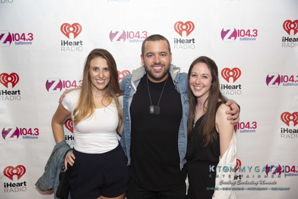 LWYD-Comedy-Tour-Baltimore-060118-FINALS-Low-Res-Watermark-296 - TOMMY GATZ ENTERTAINMENT Three people posing together, smiling at an iHeart Radio event backdrop.