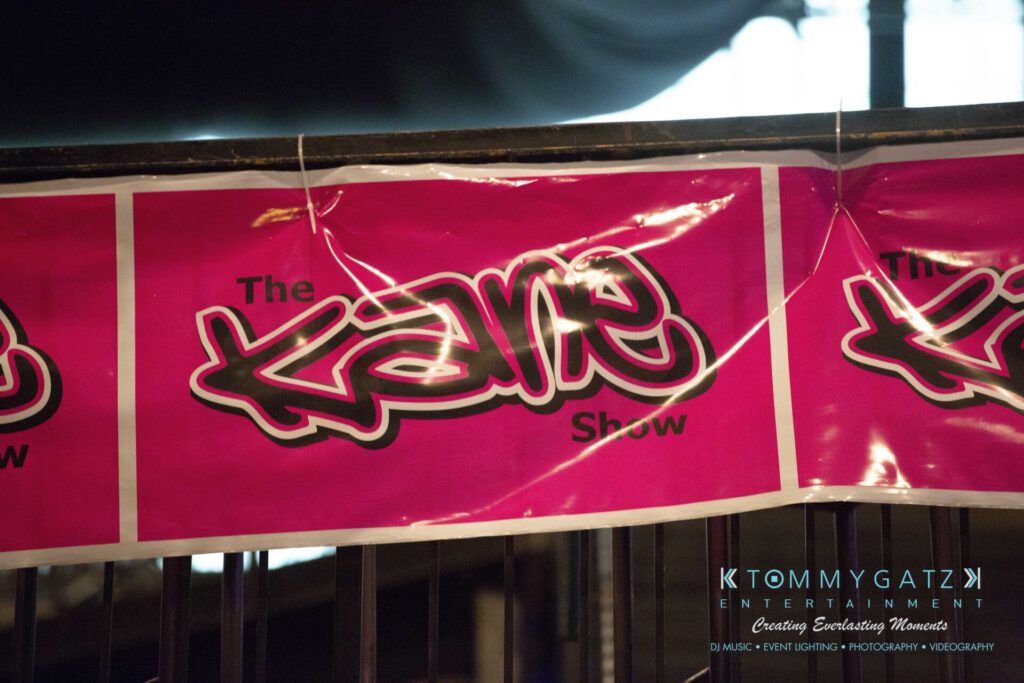 LWYD-Comedy-Tour-Baltimore-060118-FINALS-Low-Res-Watermark-3 - TOMMY GATZ ENTERTAINMENT Pink banner displaying "The Kane Show" with graffiti-style text. Company branding is visible in the corner.