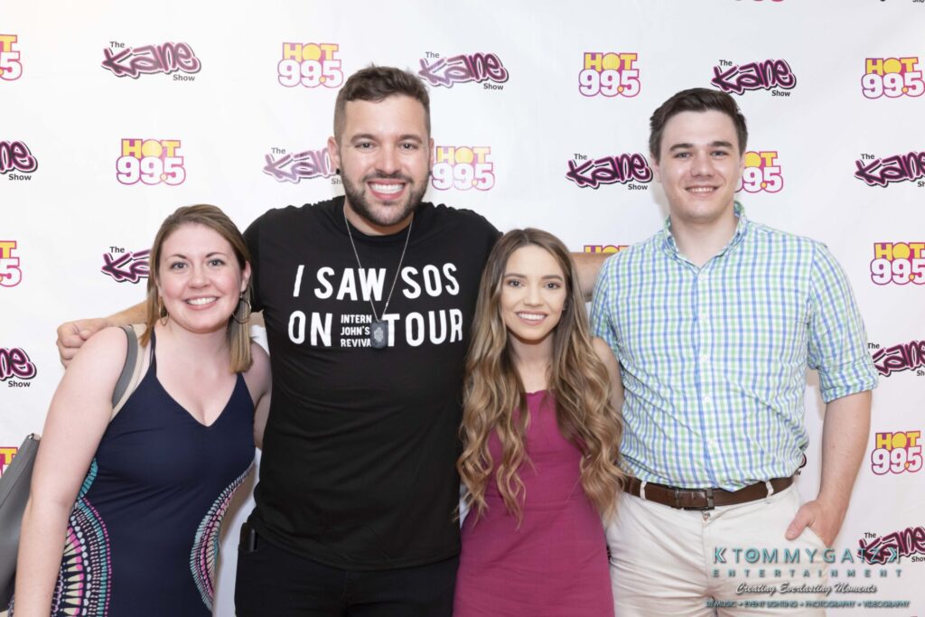 053119-Gaithersburg-ARTS-BARN-Low-Res-WM-152 - TOMMY GATZ ENTERTAINMENT Four people smiling in front of a backdrop with "Hot 99.5" and "The Kane Show" logos.