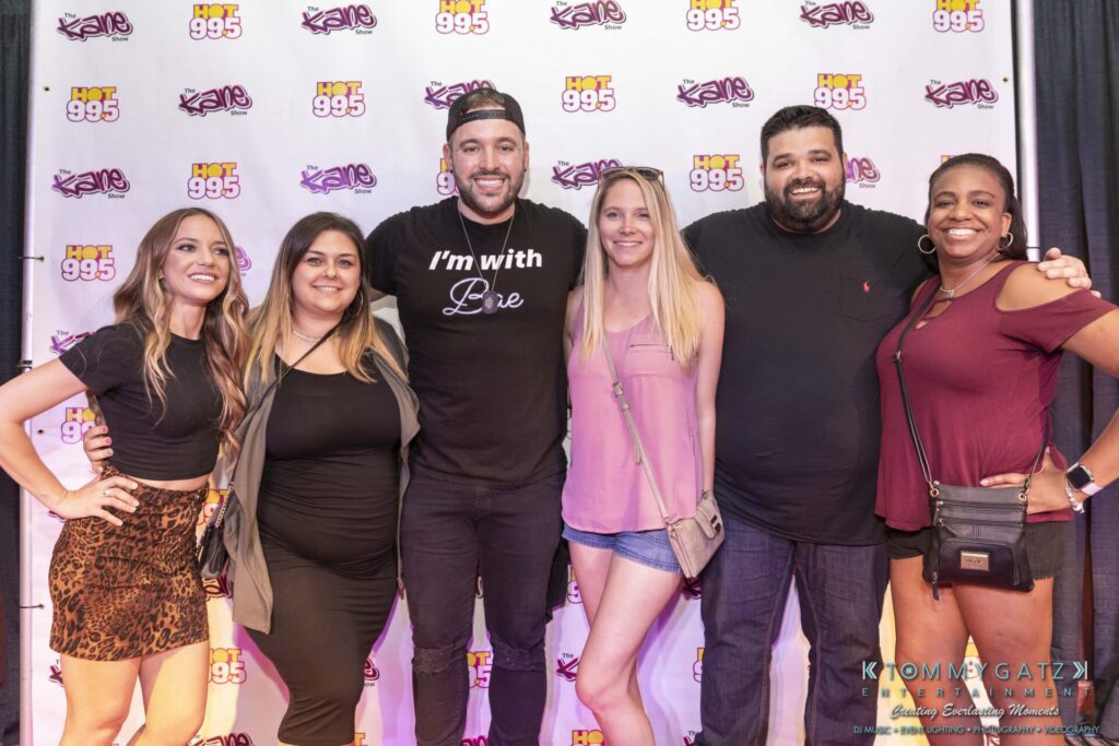 061519-Annapolis-RAMSHEAD-Low-Res-WM-202 - TOMMY GATZ ENTERTAINMENT Group of six people posing in front of a backdrop with "Hot 99.5" and "Kane Show" logos.