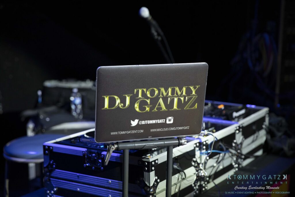 062219-Leesburg-TALLY-HO-Low-Res-WM-1 - TOMMY GATZ ENTERTAINMENT A DJ booth with equipment, featuring a laptop displaying the name "Tommy DJ Gatz.