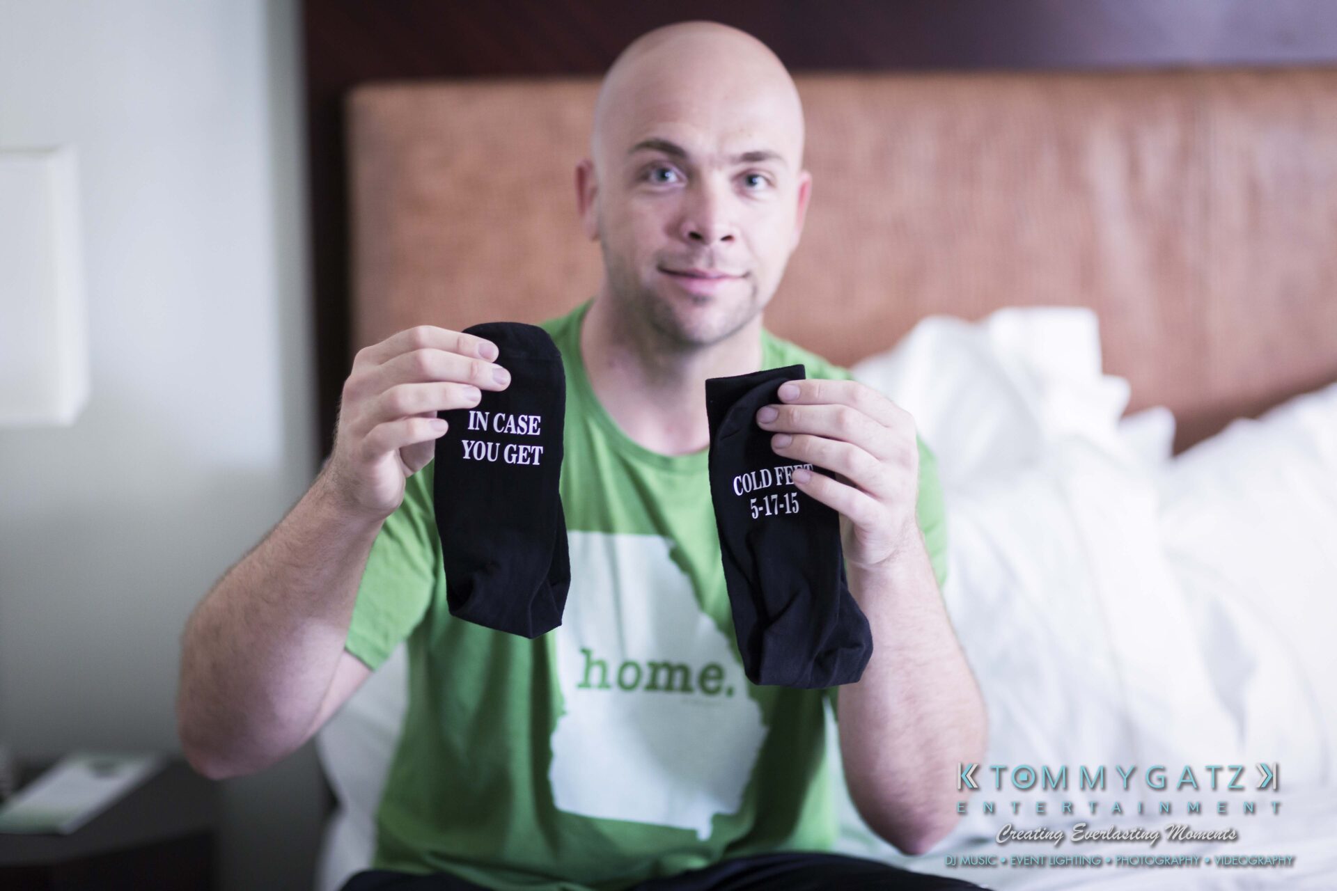 121 - TOMMY GATZ ENTERTAINMENT A person holds up two black socks. One reads, "IN CASE YOU GET COLD FEET" and the other has a date inscribed.