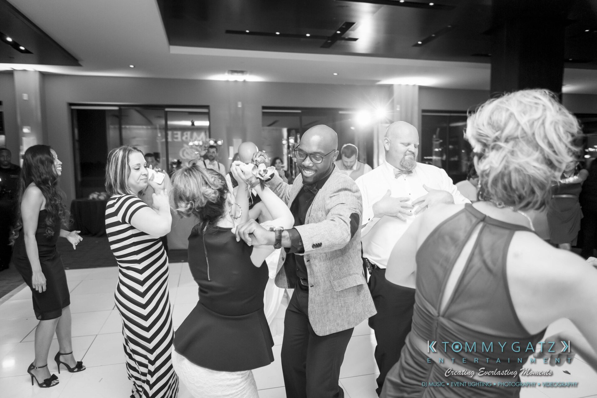 126 - TOMMY GATZ ENTERTAINMENT People dancing and having fun in a lively atmosphere at a social event.