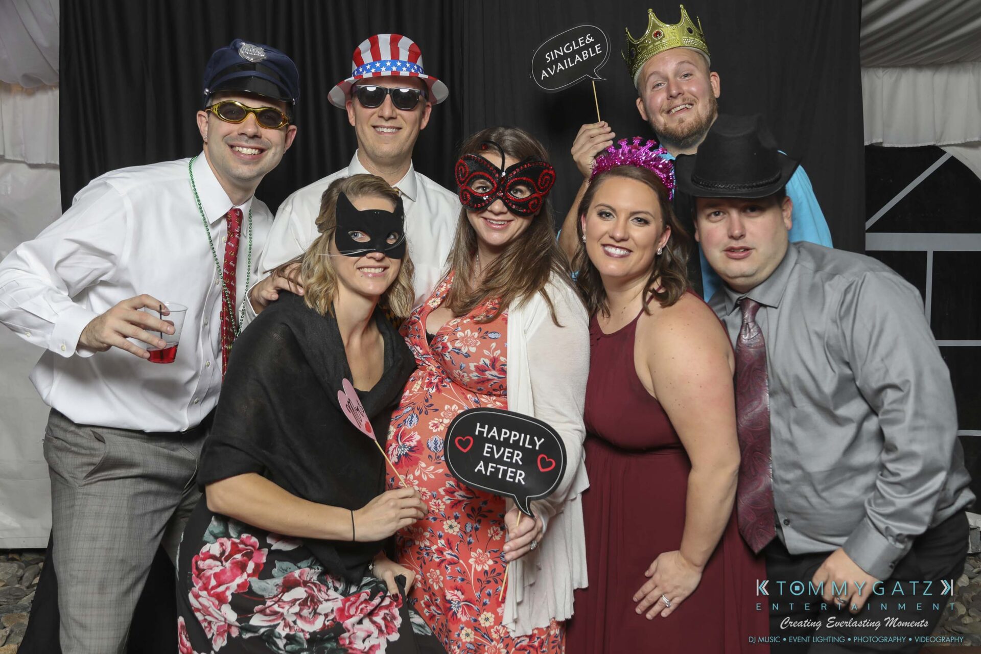 Megan-Matt-102718-Blow-WM-18 - TOMMY GATZ ENTERTAINMENT A group of people in festive attire pose with masks and signs at a party.