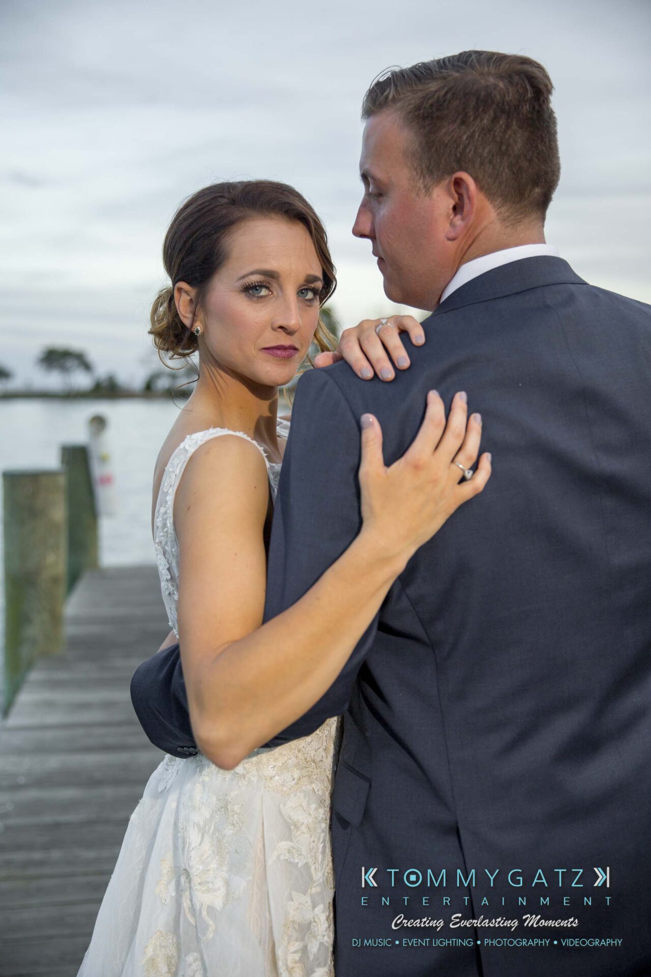 Amanda-Tyler-102117-FORMALS-Low-Res-WM-56 - TOMMY GATZ ENTERTAINMENT A couple stands on a dock by the water; the woman faces the camera while the man looks away.