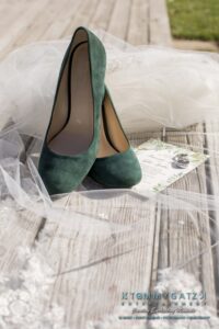 Amanda-Tyler-102117-PREP-Low-Res-WM-14 - TOMMY GATZ ENTERTAINMENT Green high heels on a wooden deck, surrounded by a veil and a floral invitation.