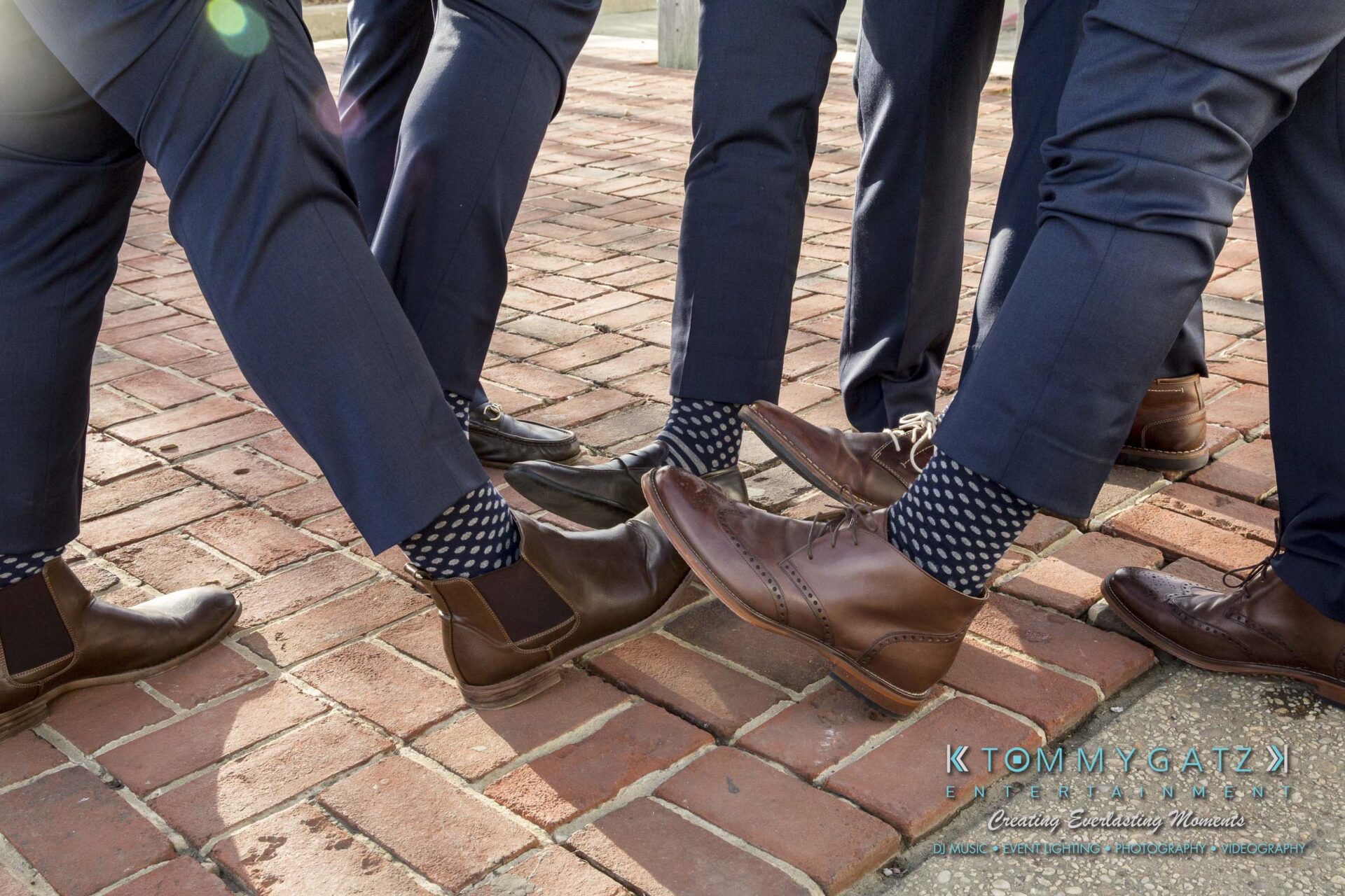 Amanda-Tyler-102117-PREP-Low-Res-WM-225 - TOMMY GATZ ENTERTAINMENT Five men in dark suits and patterned socks stand in a circle on a brick surface, showing off their brown dress shoes.