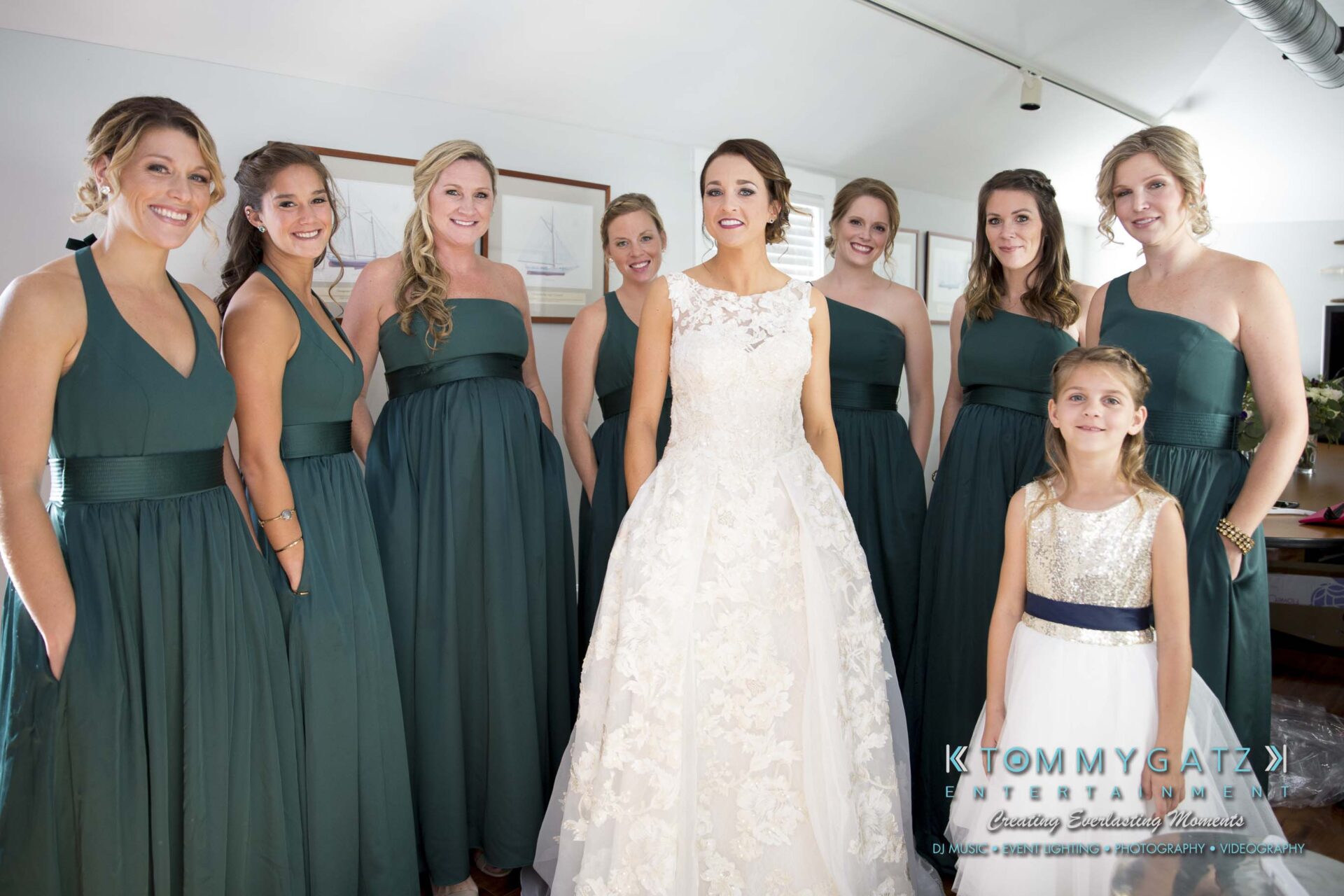 Amanda-Tyler-102117-PREP-Low-Res-WM-45 - TOMMY GATZ ENTERTAINMENT A bride in a white gown stands with her bridesmaids in dark green dresses and a young girl in a white dress.