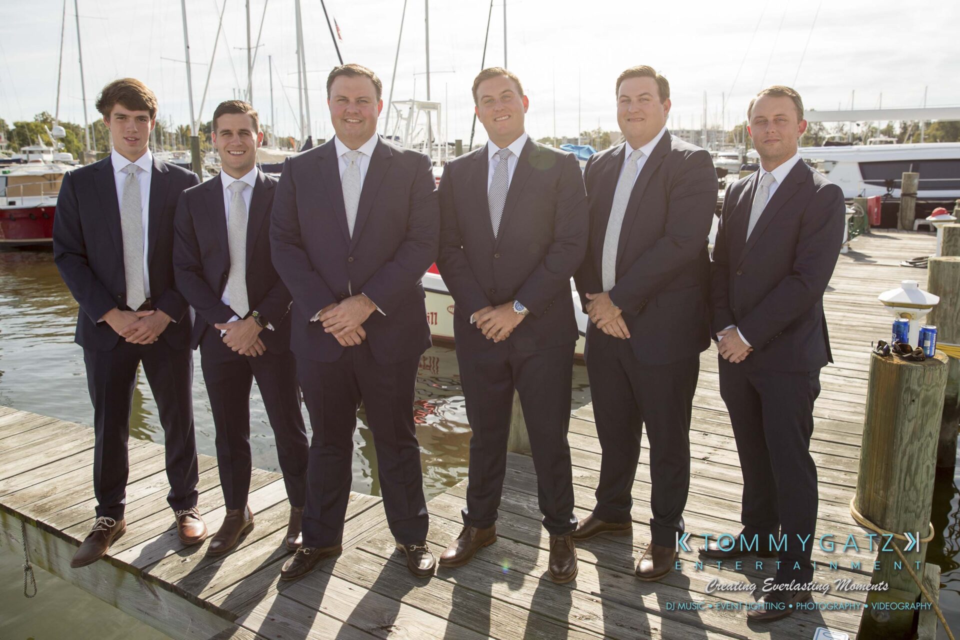 Amanda-Tyler-102117-PREP-Low-Res-WM-62 - TOMMY GATZ ENTERTAINMENT Six men in suits stand on a dock in front of boats, posing for a group photo.