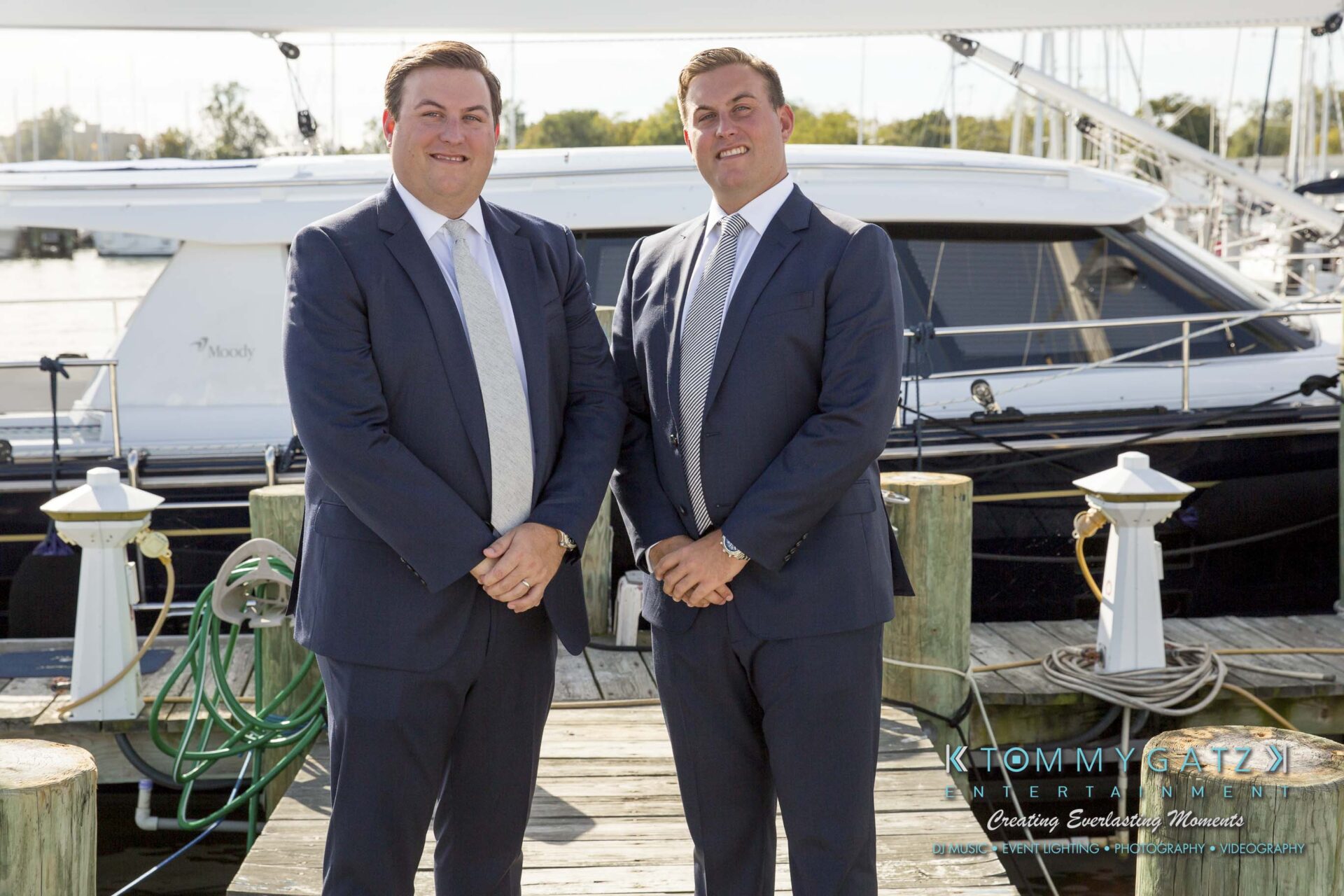 Amanda-Tyler-102117-PREP-Low-Res-WM-74 - TOMMY GATZ ENTERTAINMENT Two men in suits standing on a dock in front of a yacht.