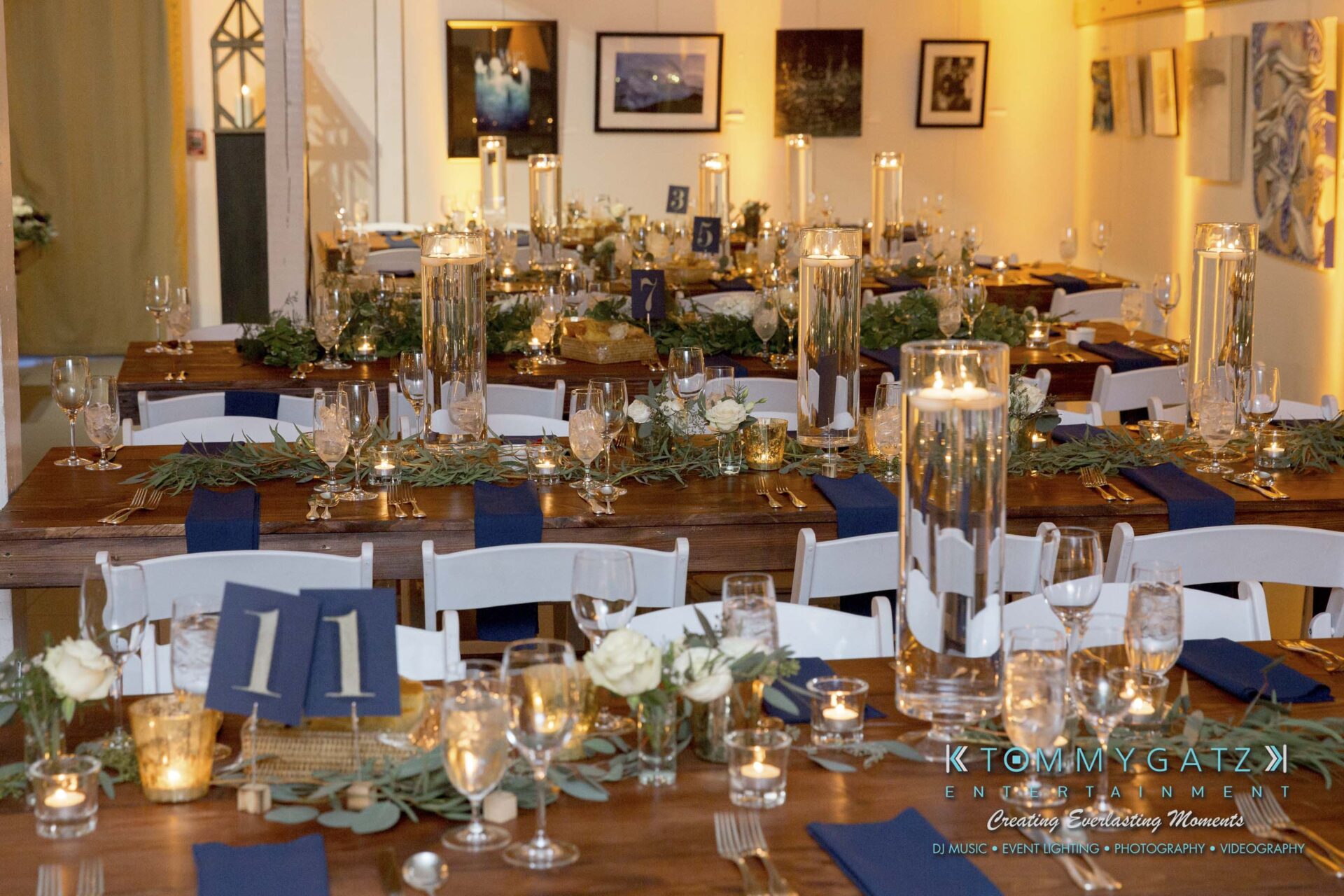 Amanda-Tyler-102117-RECEPTION-Low-Res-WM-5 - TOMMY GATZ ENTERTAINMENT Elegant wedding reception table setup with numbered navy table runners, tall candleholders, and greenery centerpieces.