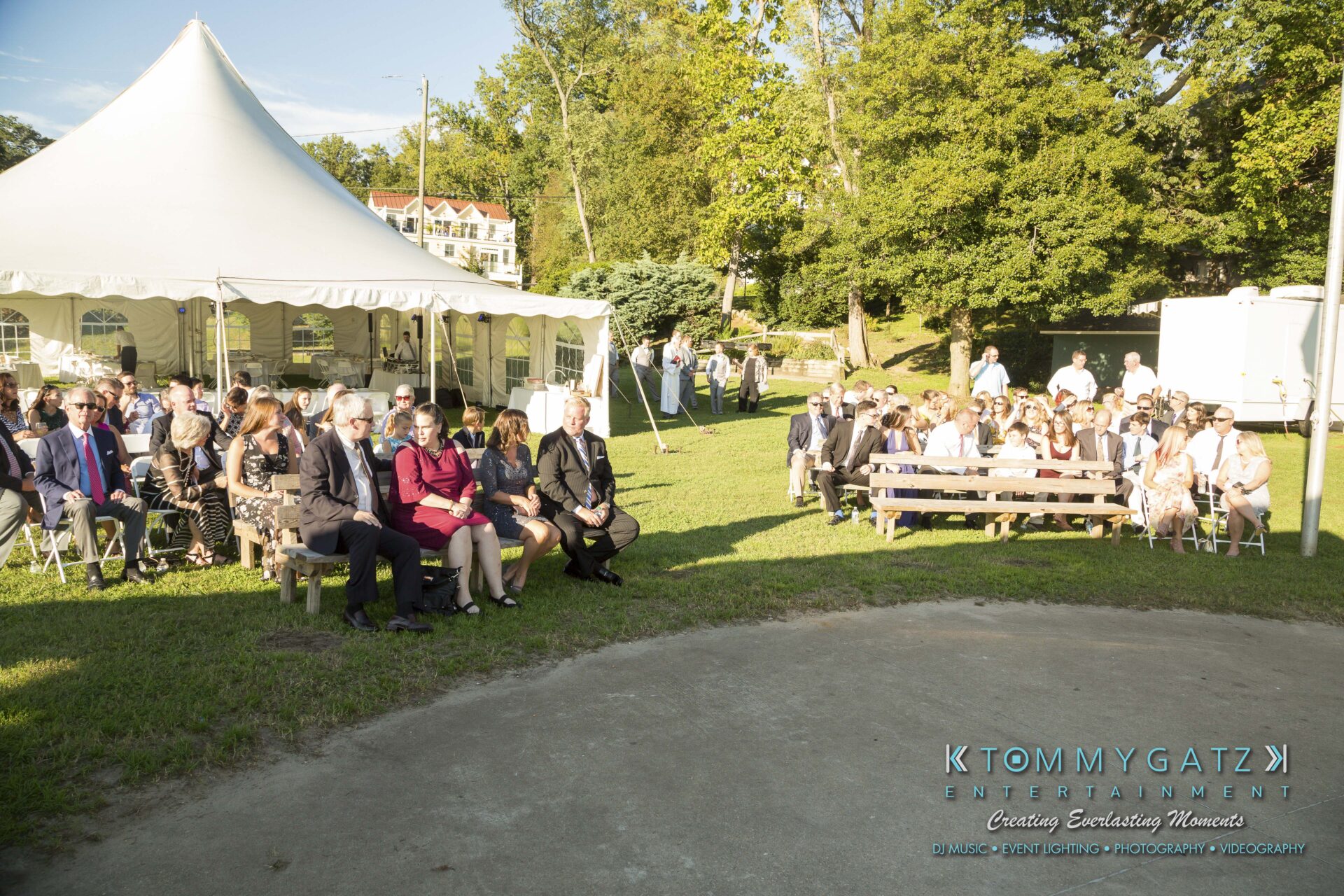 Ann-Marie-Alex-92317-CEREMONY-Low-Res-WM-2 - TOMMY GATZ ENTERTAINMENT Outdoor wedding ceremony with guests seated under a white tent on a sunny day.