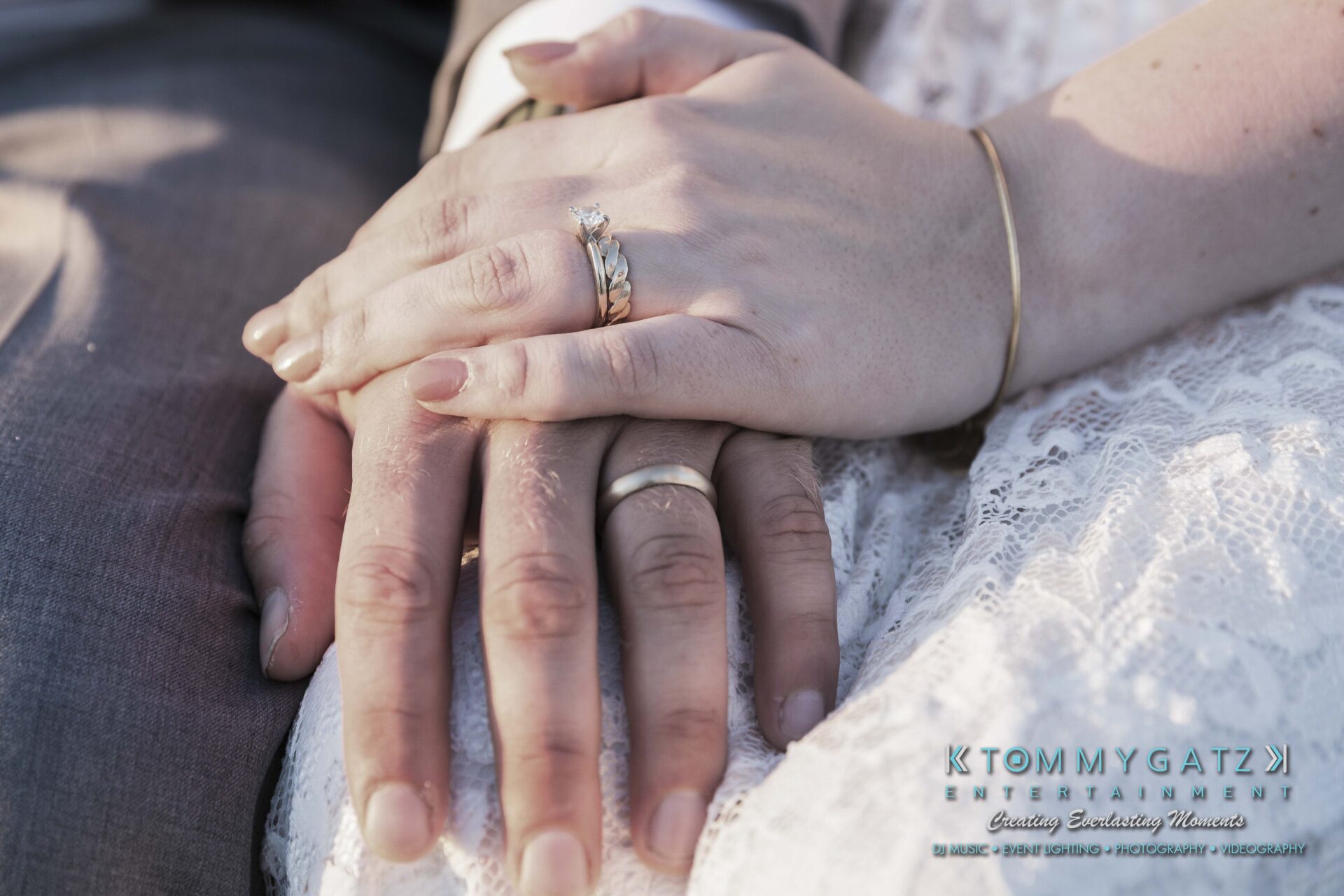 Ann-Marie-Alex-92317-FORMALS-Low-Res-WM-42 - TOMMY GATZ ENTERTAINMENT Close-up of two hands with wedding rings resting on a lace dress.