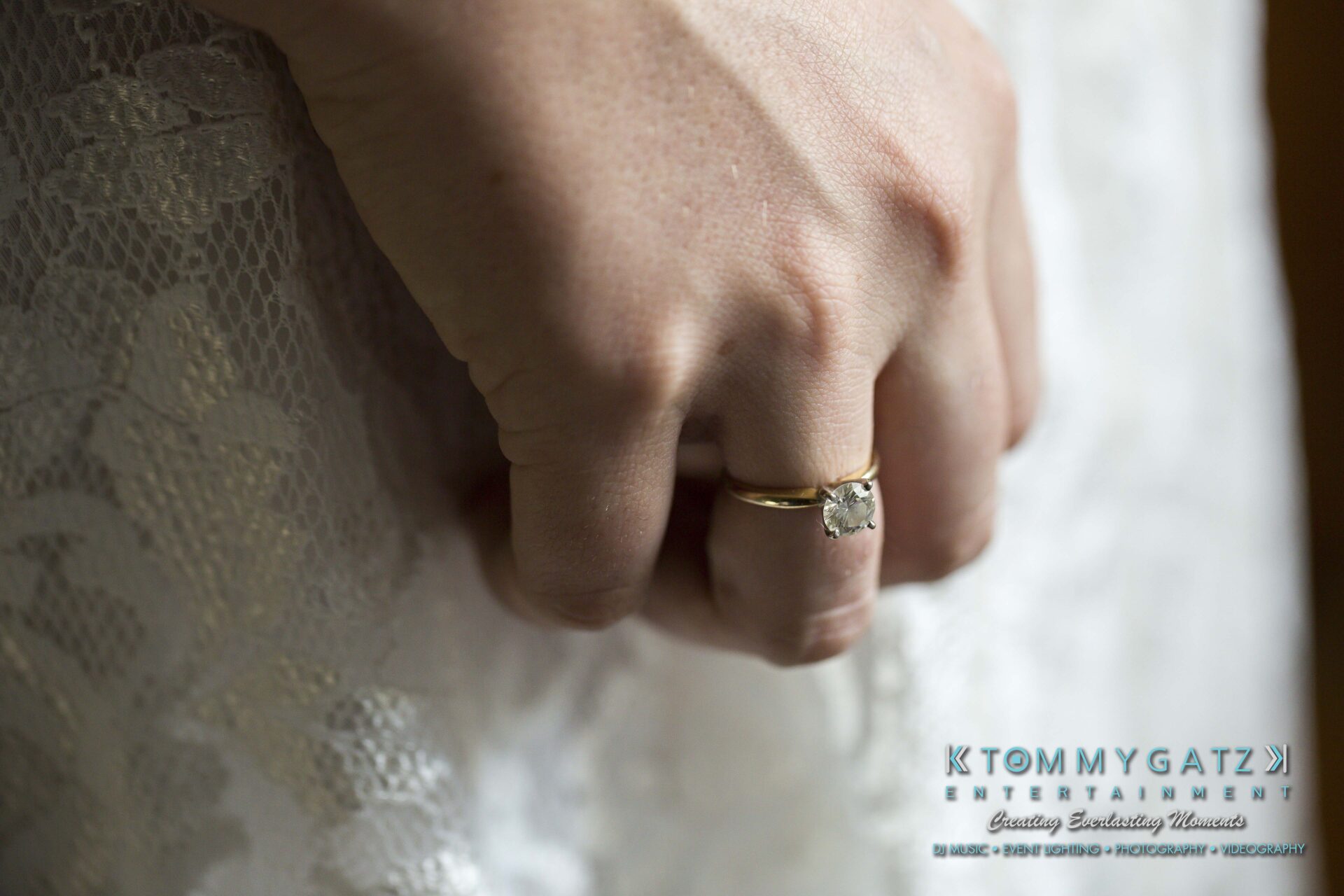 Ann-Marie-Alex-92317-PREP-Low-Res-WM-133 - TOMMY GATZ ENTERTAINMENT A close-up of a hand wearing a gold ring with a round diamond. The person is dressed in lace fabric.