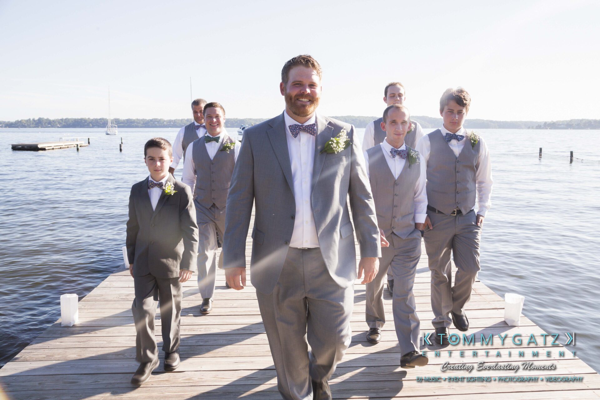 Ann-Marie-Alex-92317-PREP-Low-Res-WM-29 - TOMMY GATZ ENTERTAINMENT A group of men and boys in suits and vests walk on a dock by the water.