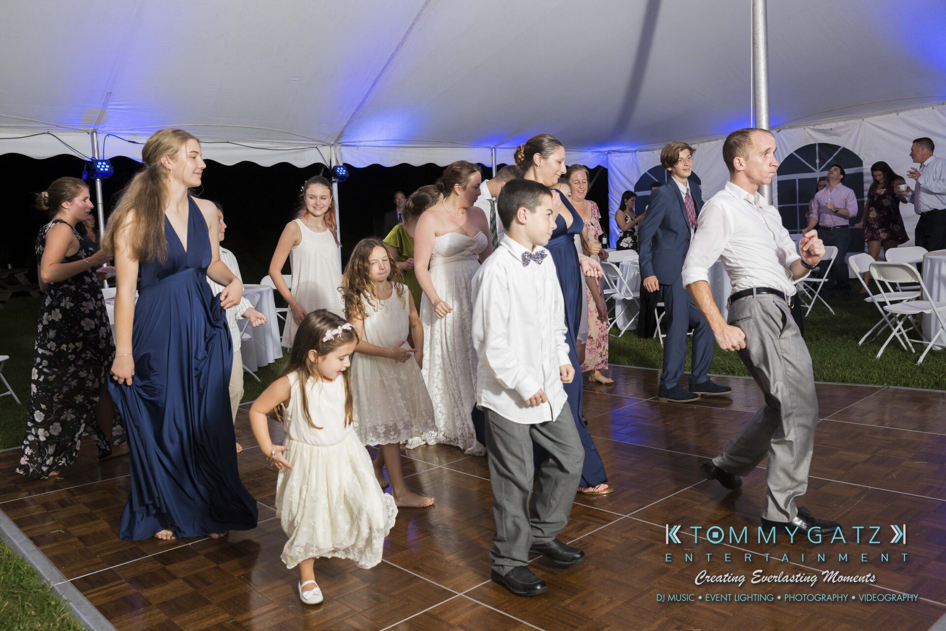 Ann-Marie-Alex-92317-RECEPTION-Low-Res-WM-120 - TOMMY GATZ ENTERTAINMENT People of various ages dancing under a white tent at an event, wearing semi-formal attire.